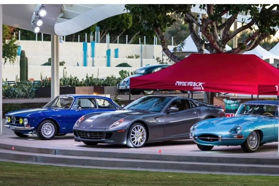 Luxury and classic sports cars on display during a Scottsdale car show featuring Ferrari, Jaguar, and vintage European automobiles.