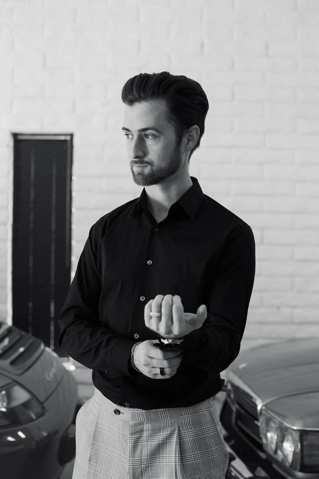 Cody Wolfe, luxury real estate agent and Partner at The Agency Scottsdale, standing with vintage cars