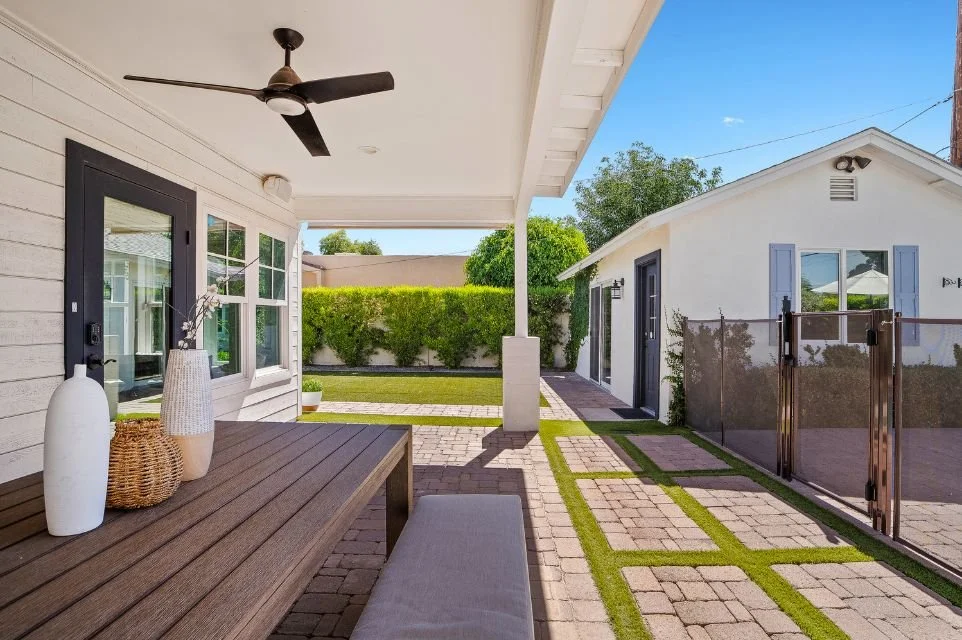 Covered Arcadia Lite patio with outdoor dining area, paver walkway, guest casita, ceiling fan, and landscaped backyard designed for indoor-outdoor living in Phoenix Arizona