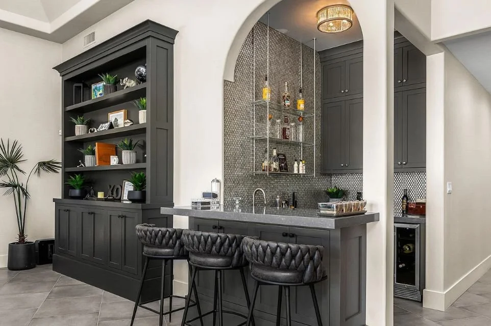 Built-in home bar with dark cabinetry and counter seating in a Paradise Valley luxury home