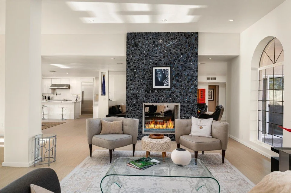A high end room with a designer tile fireplace and high end furniture