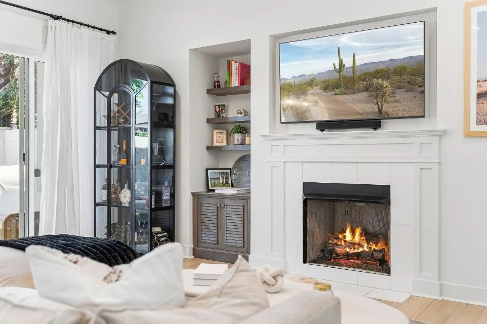Elegant Scottsdale living room with gas fireplace, custom built-ins, natural light, and modern luxury finishes in a high-end residential home.