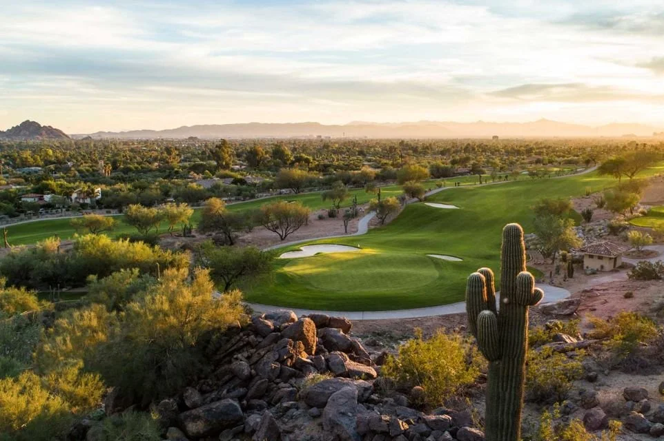 Scenic golf course at The Phoenician in Scottsdale, Arizona, featuring lush fairways, towering saguaro cacti, and panoramic Camelback Mountain views.