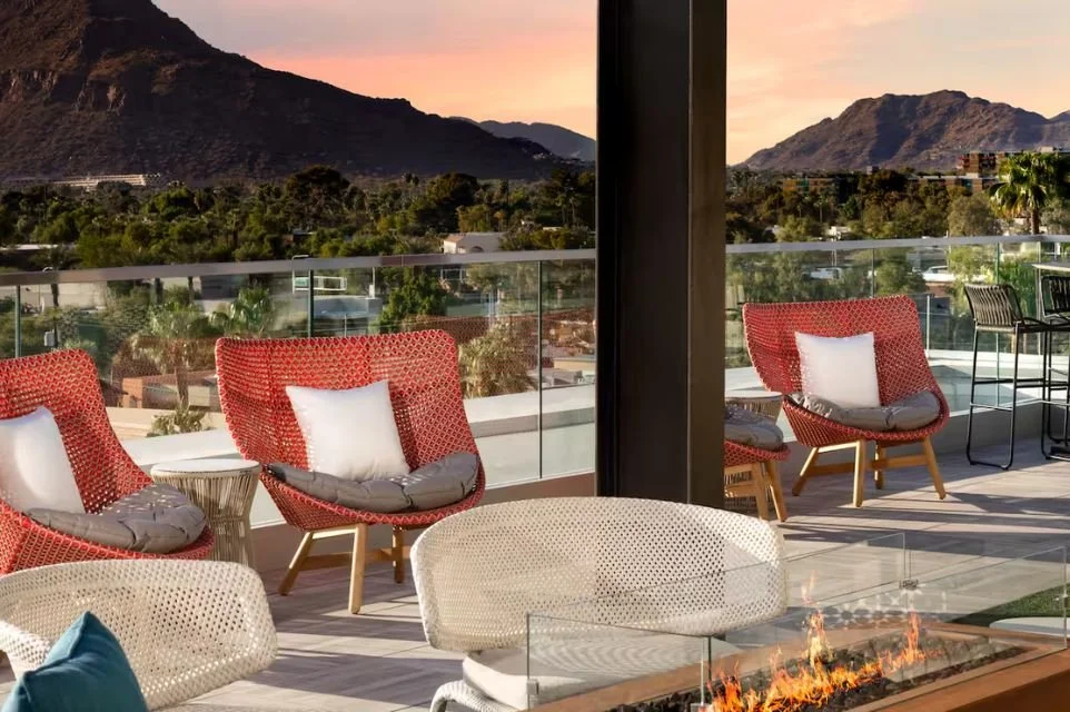 Rooftop lounge at Canopy by Hilton Scottsdale Old Town with Camelback Mountain views, modern fire feature, and outdoor seating at sunset.