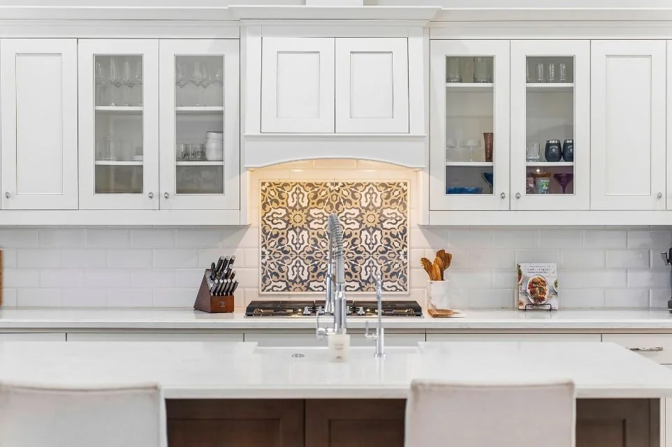 Custom luxury kitchen in Scottsdale featuring white shaker cabinets, designer tile backsplash, large island, and premium stainless steel appliances.