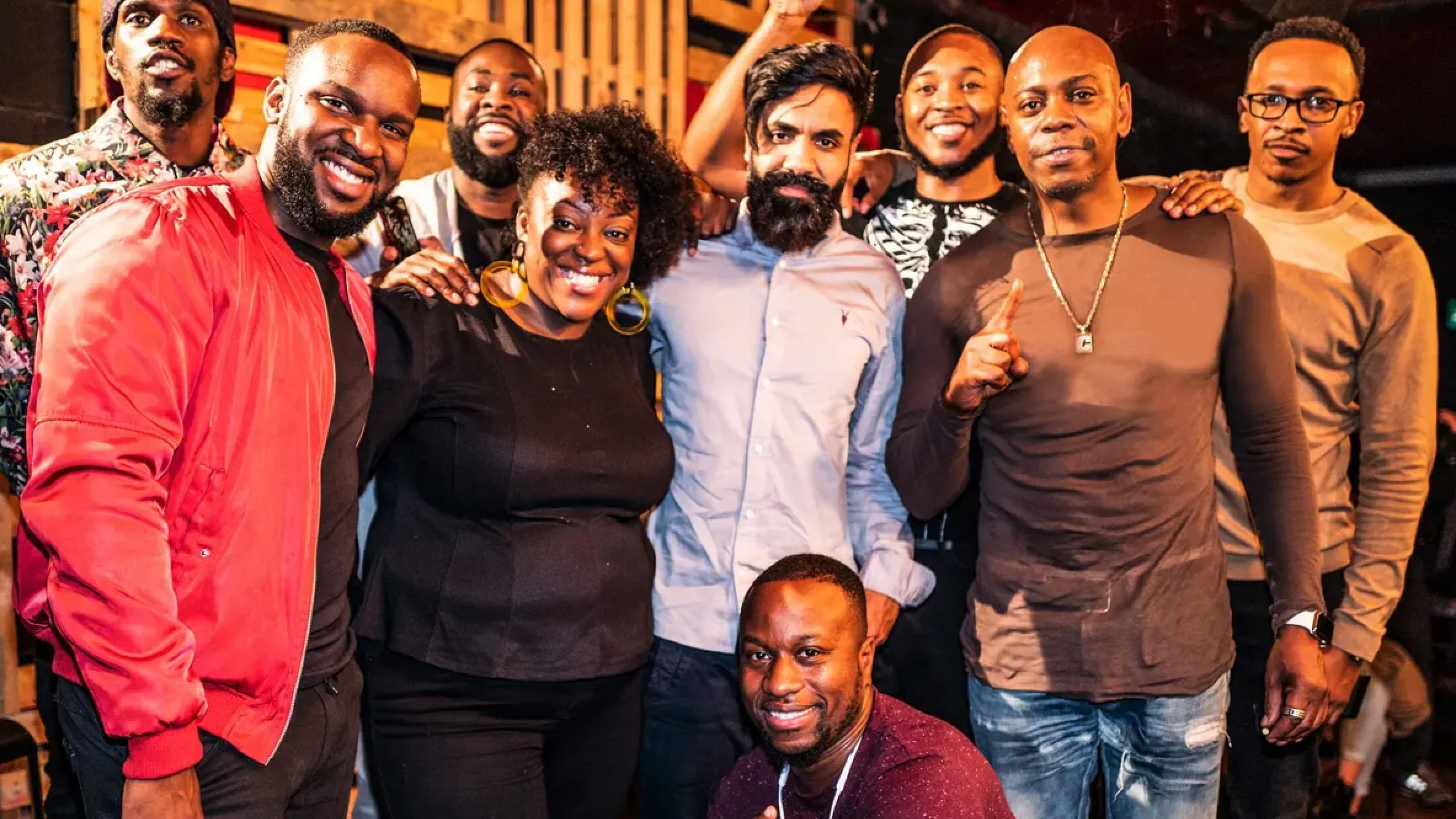 Group of ten people smiling and posing together at a social gathering or event.