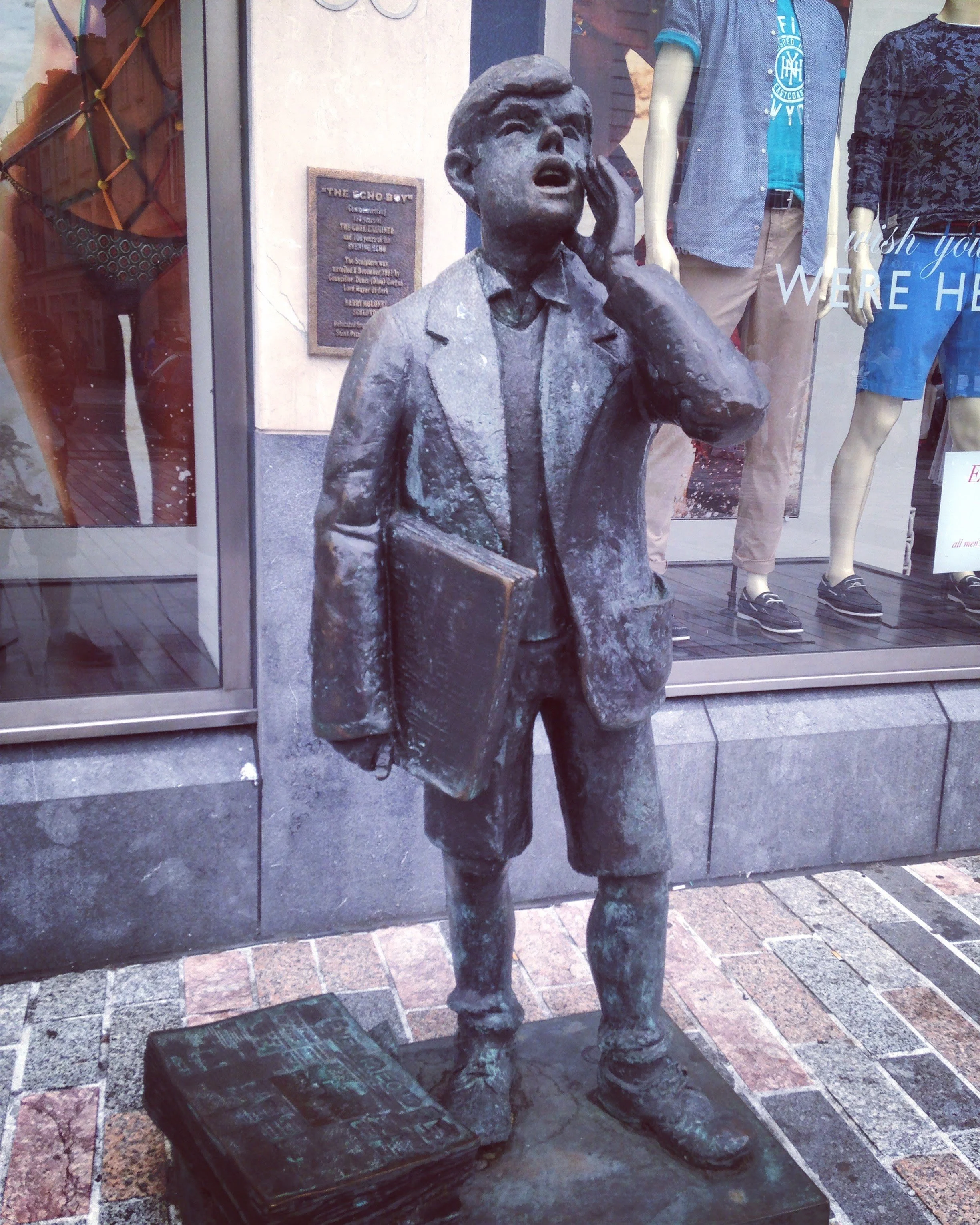 picture of a statue of the echo boy in cork, young boy shouting while holding papers
