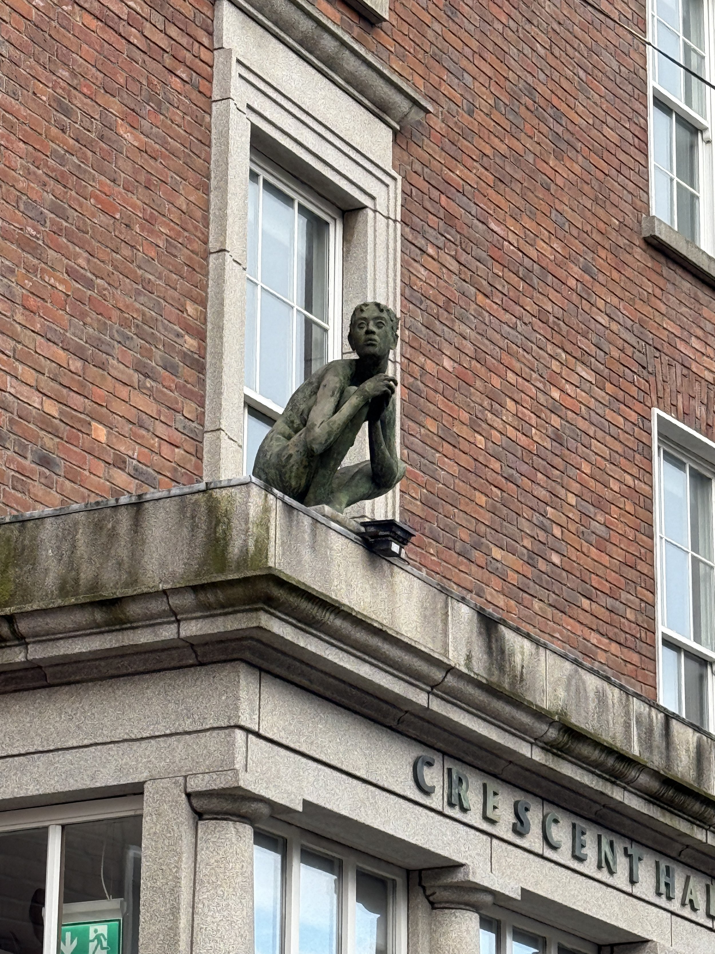 close up of statue crouched on building ledge
