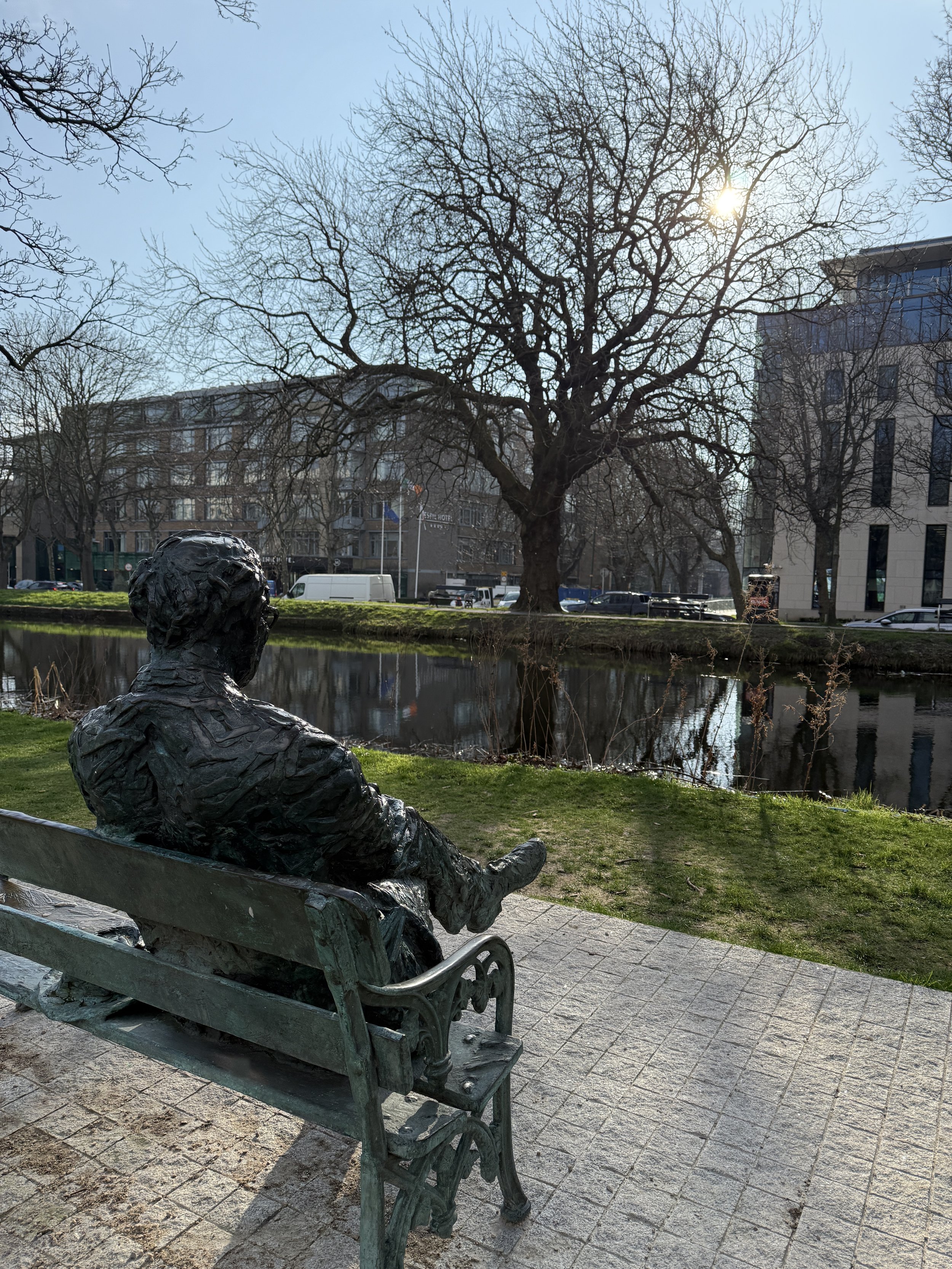 photo of statue from behind of paddy kavanagh  sitting on a bench