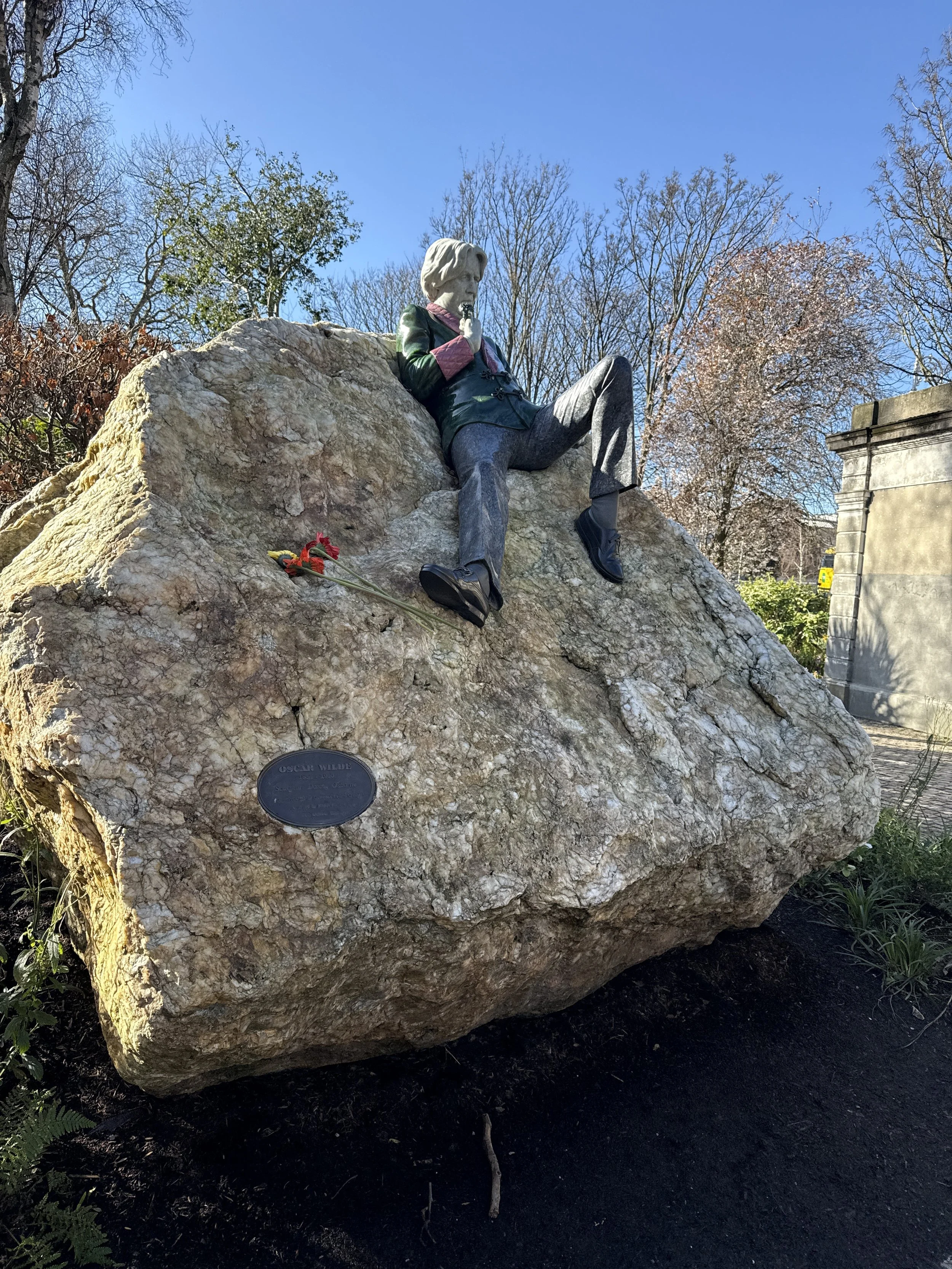 oscar wilde sitting on a rock