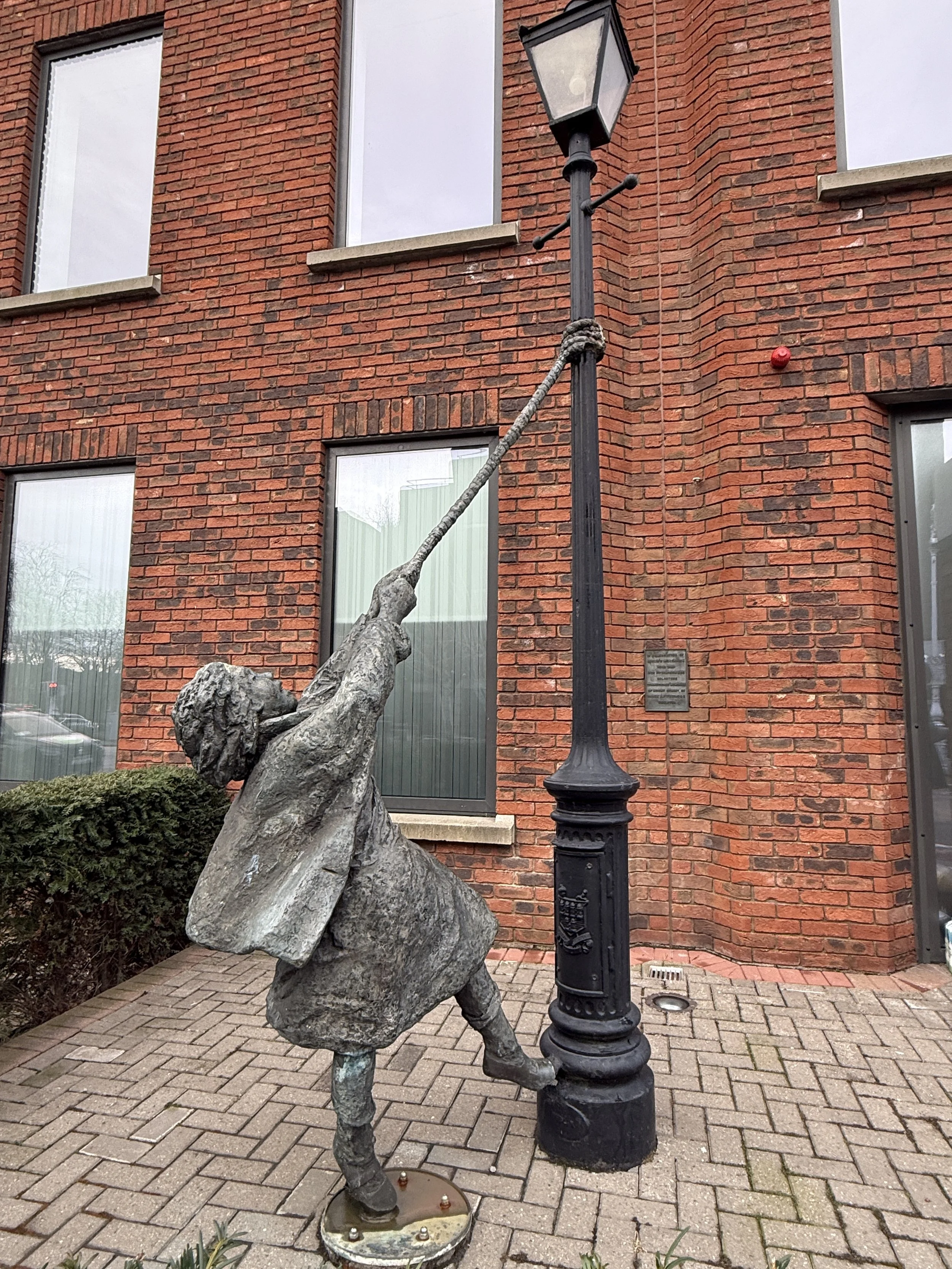 statue of girl swinging from lamppost