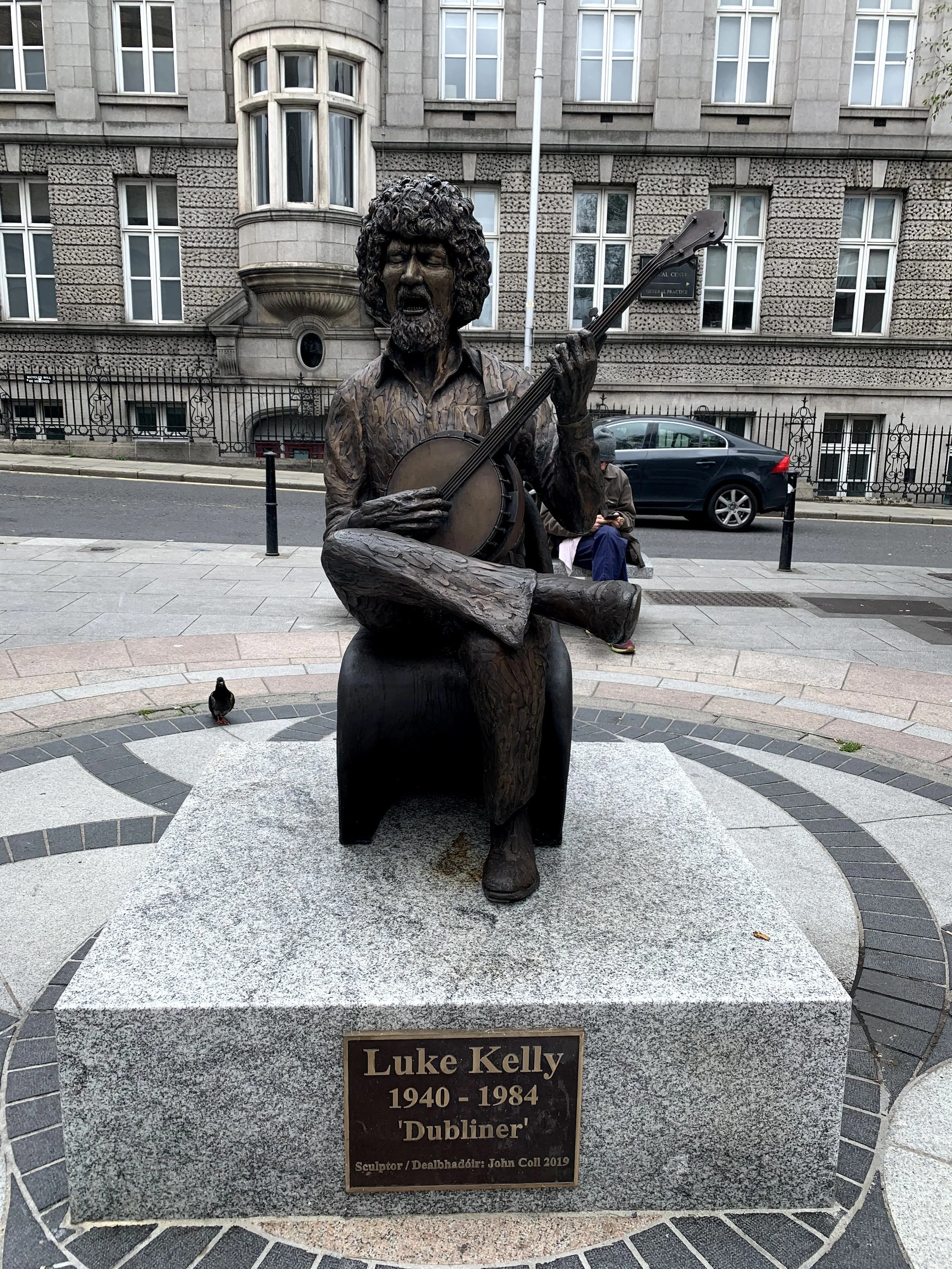 Statue of luke kelly sitting down playing banjo