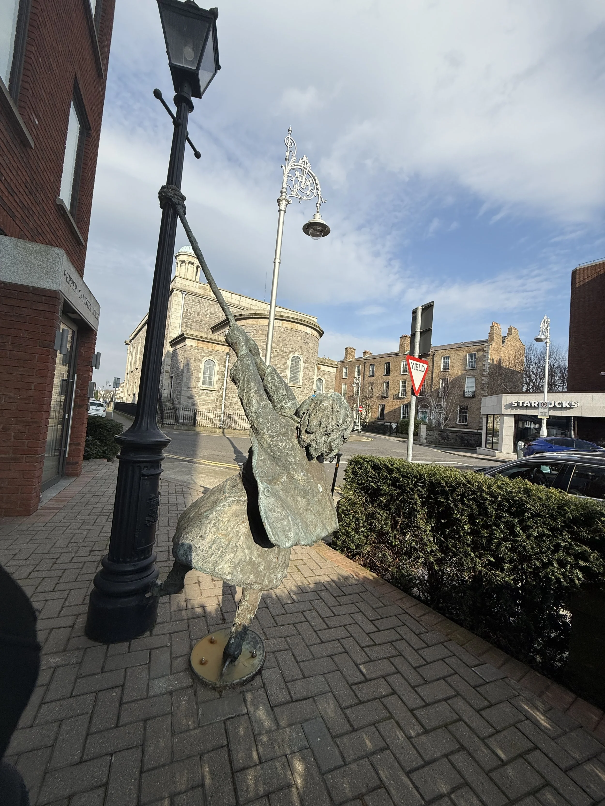 statue of girl swinging off lamppost