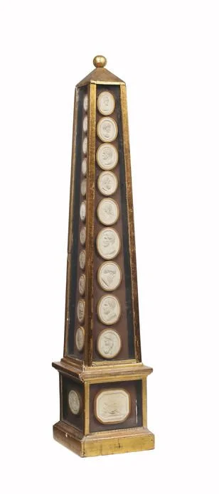 An giltwood obelisk mounted with 45 19th Century Grand Tour plaster intaglios.
