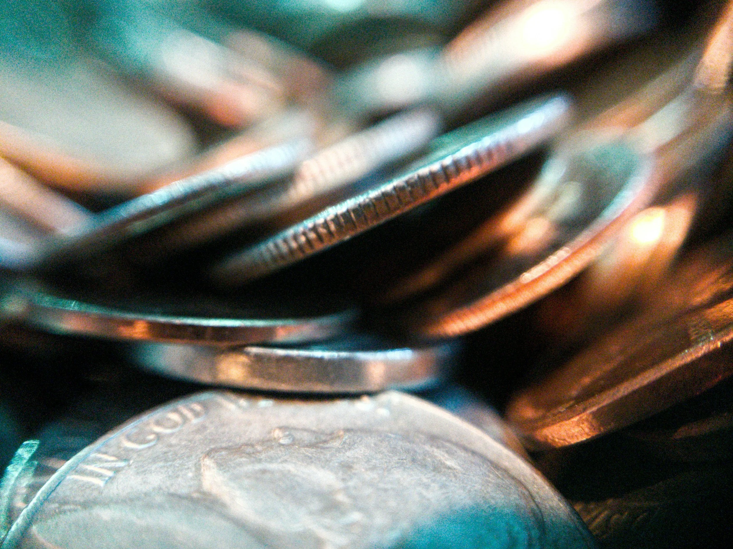 Close-up photo of various coins stacked and overlapping.