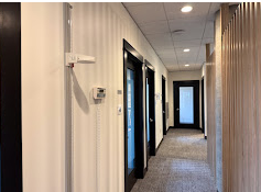 Hallway with wood-paneled walls and several doors leading to different rooms.