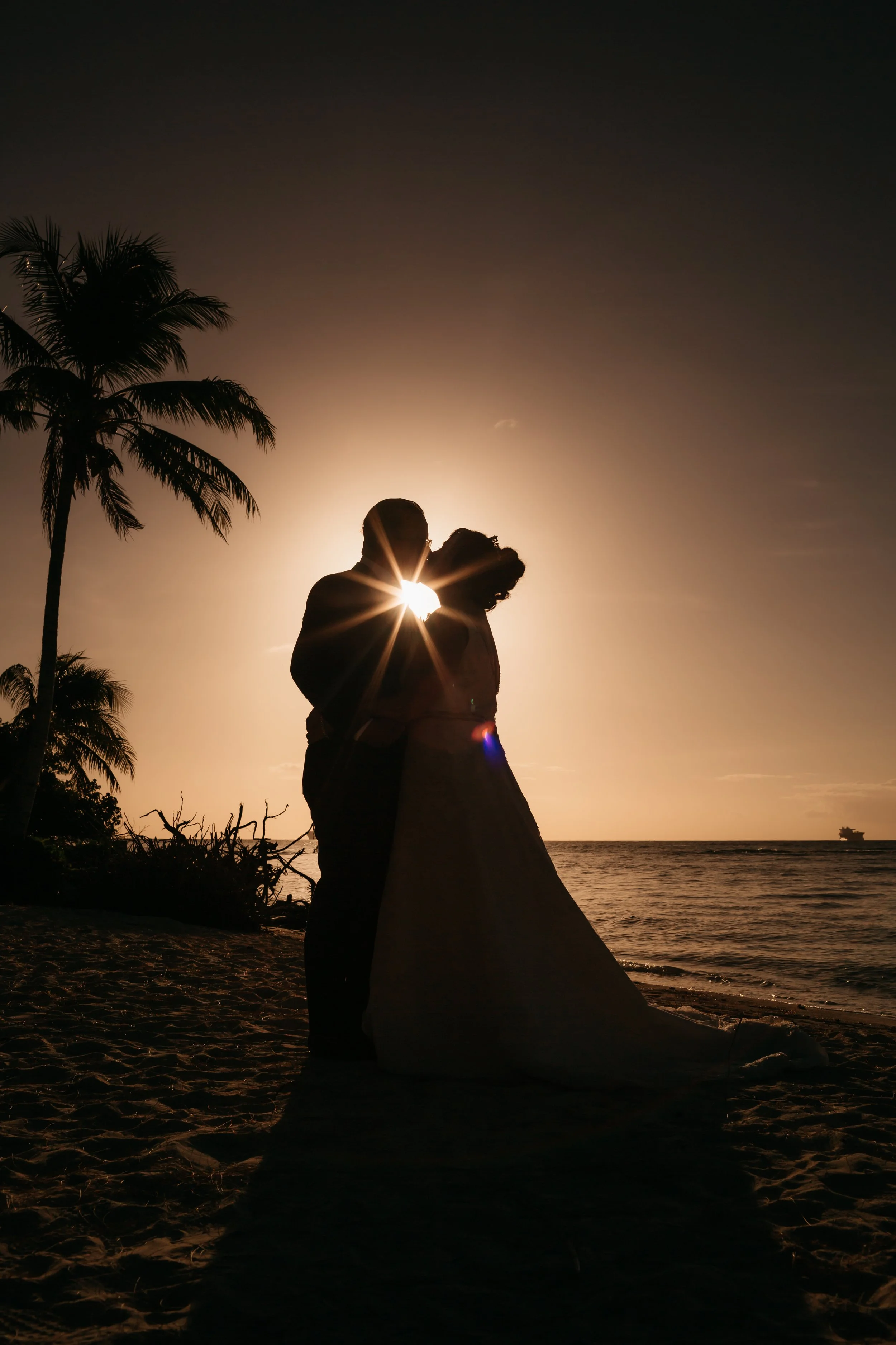 couple on the beach kissing with a solar eclipse background