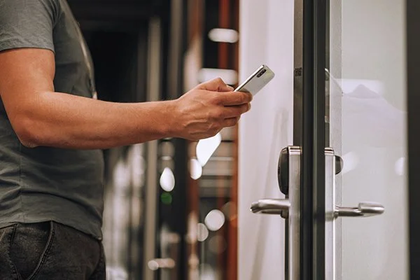 A person entering a commercial premises with a Smart Lock using a smartphone .