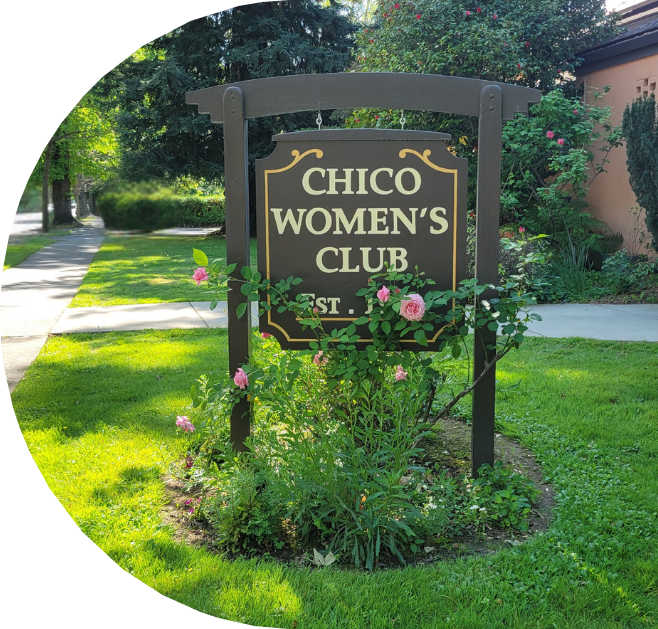 Sign for Chico Women's Club with pink roses and greenery in a well-maintained garden on a sunny day.