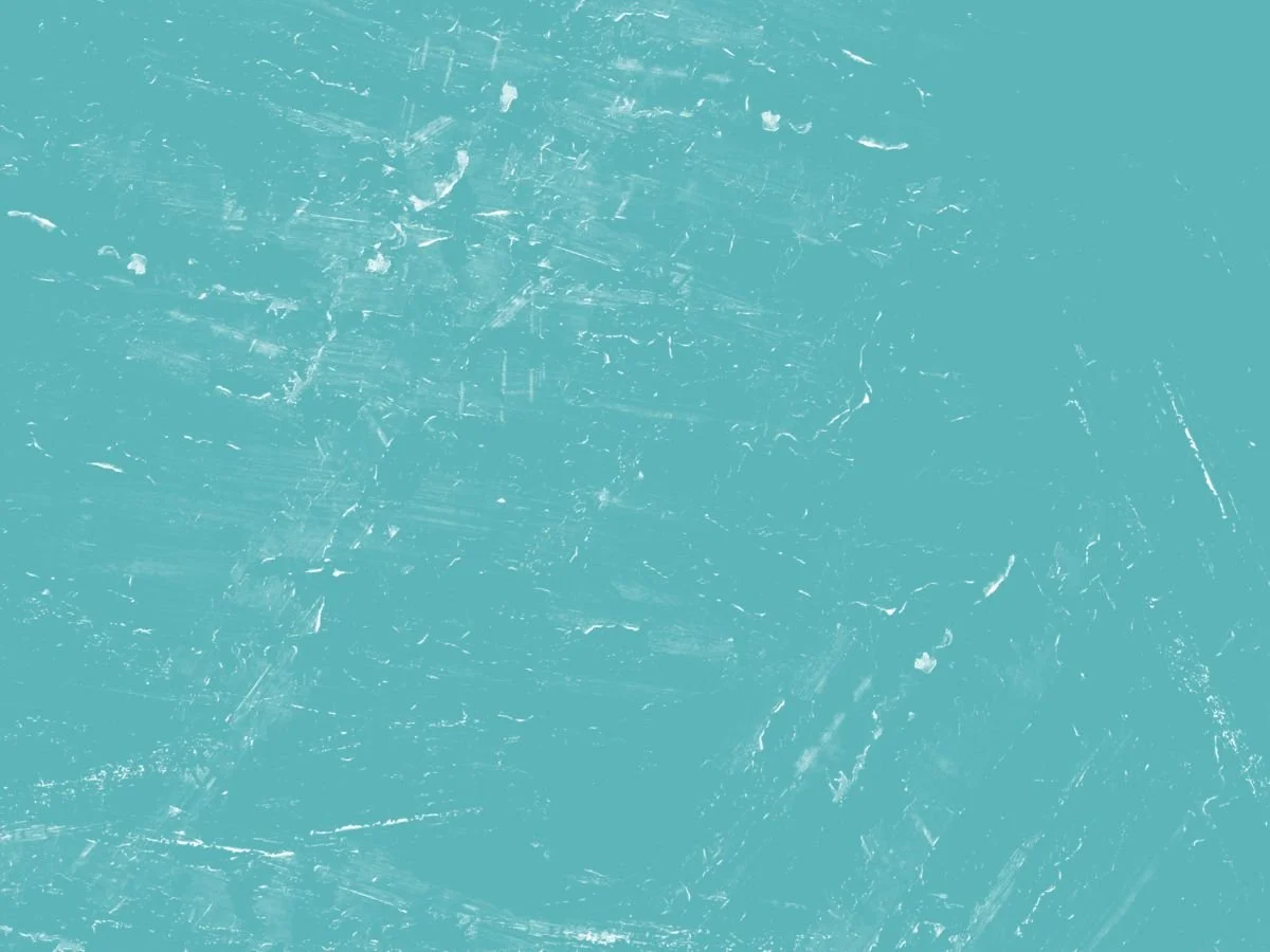 A teal-colored textured surface with scratches and marks.