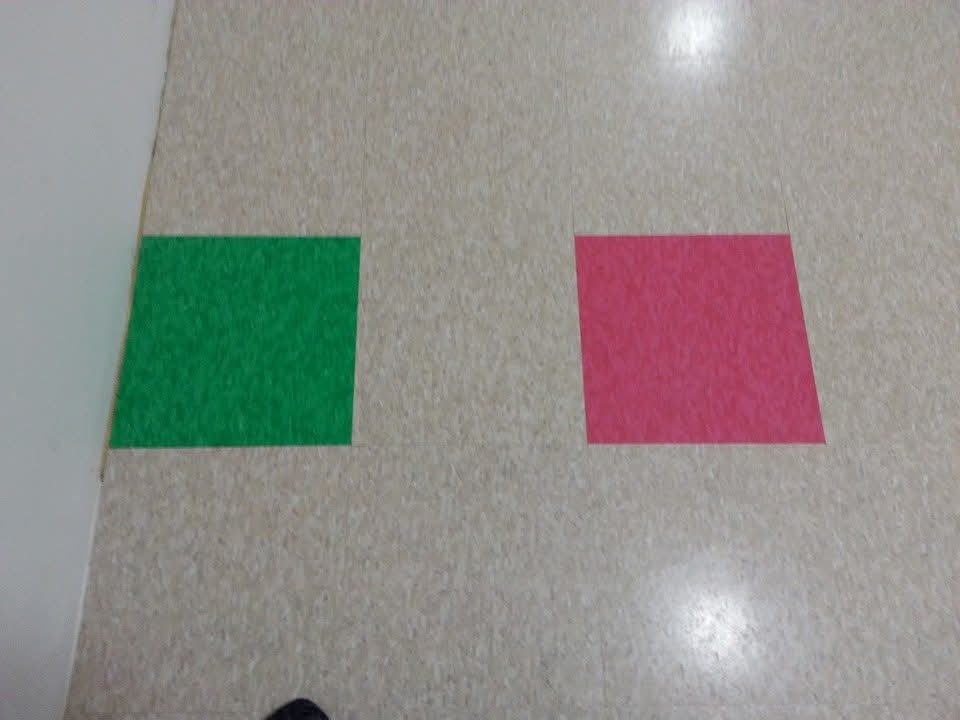 Colorful squares on a tiled floor, with a green square on the left and a pink square on the right.