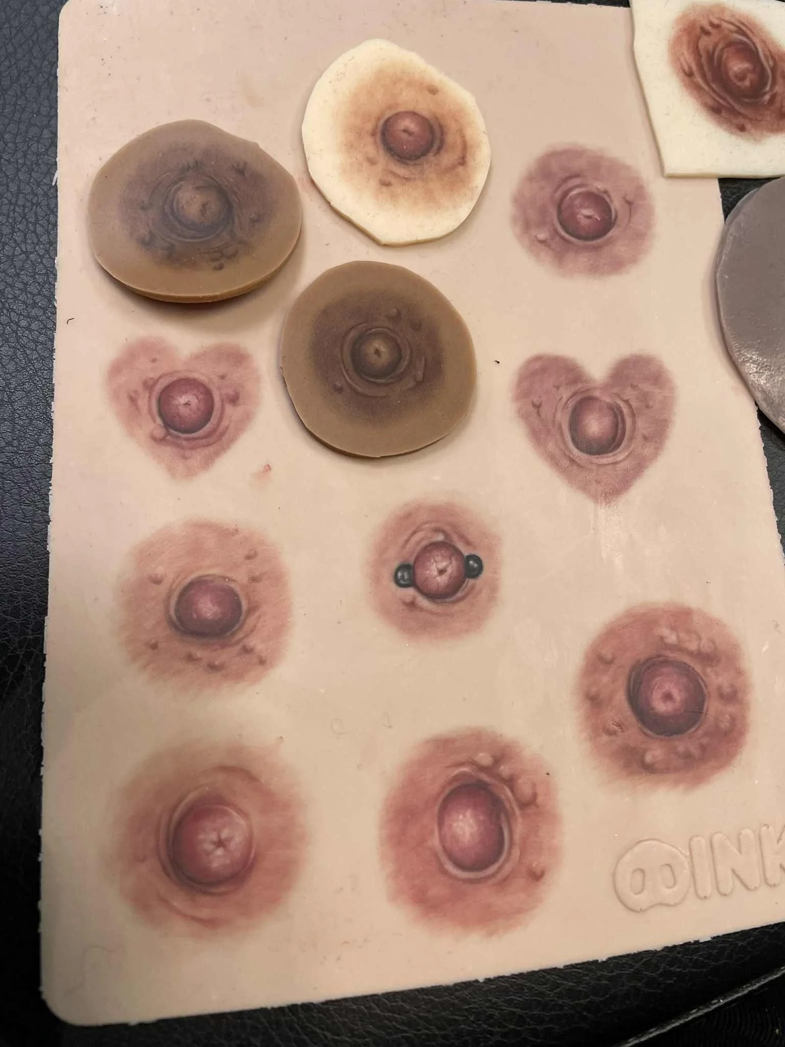 Assortment of Areola tattoos on fake skin showing a wide variety of colours and shapes