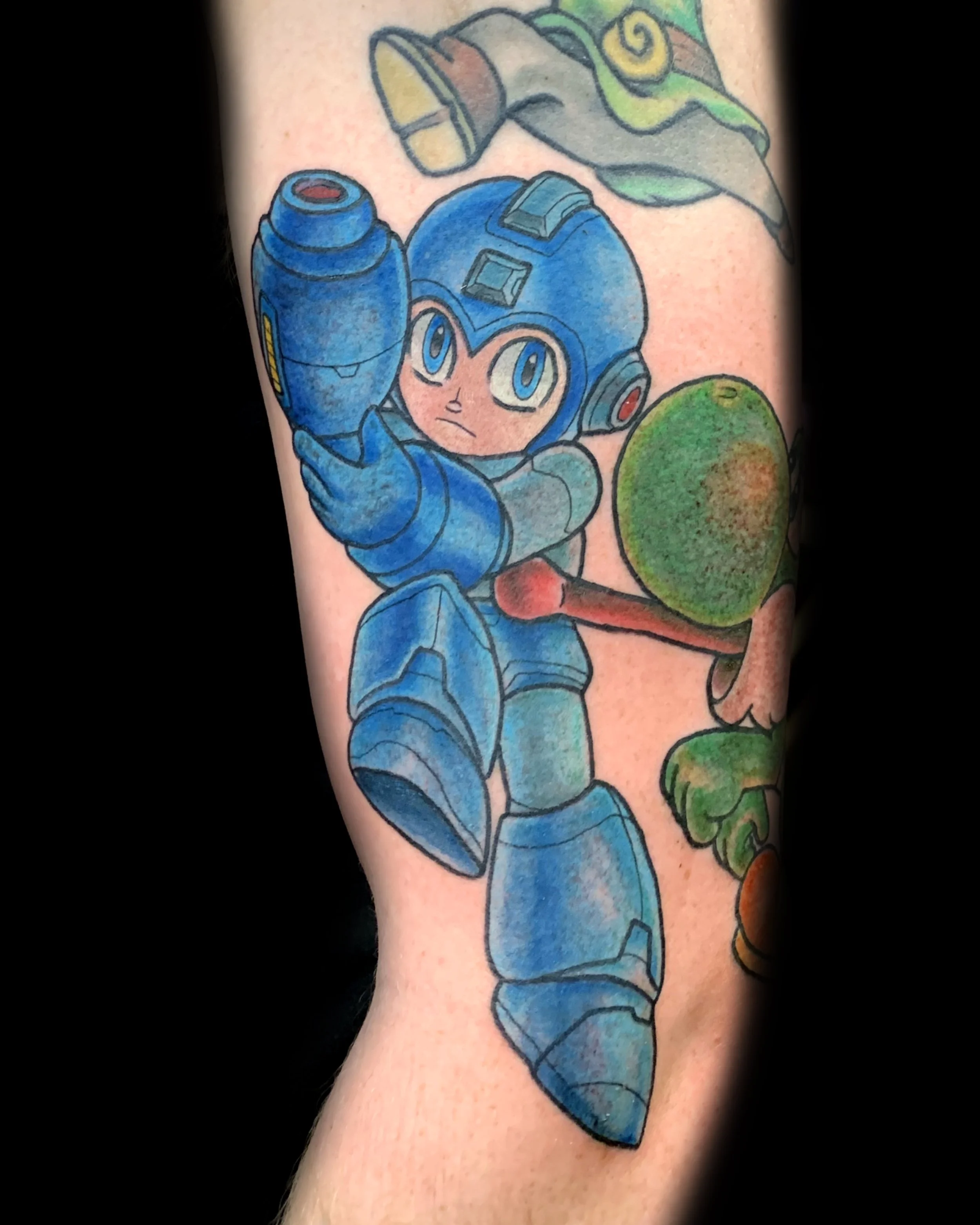 Mega Man inspired bright colorful tattoo on arm. Clean lines. Vegan tattooer, van-life tattooer, climbing tattooer