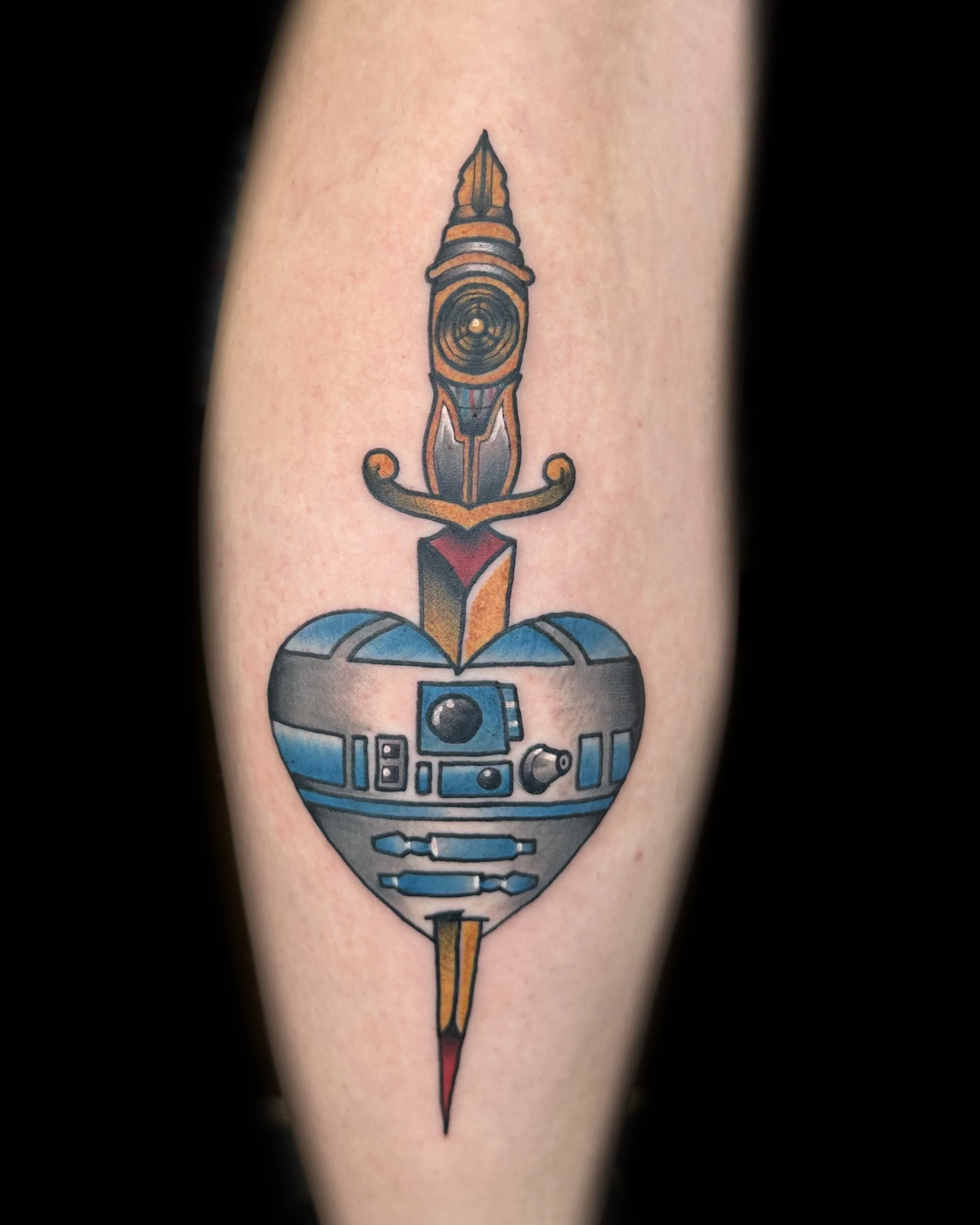 Tattoo of a sword piercing a heart-shaped droid from Star Wars, with intricate details and color.