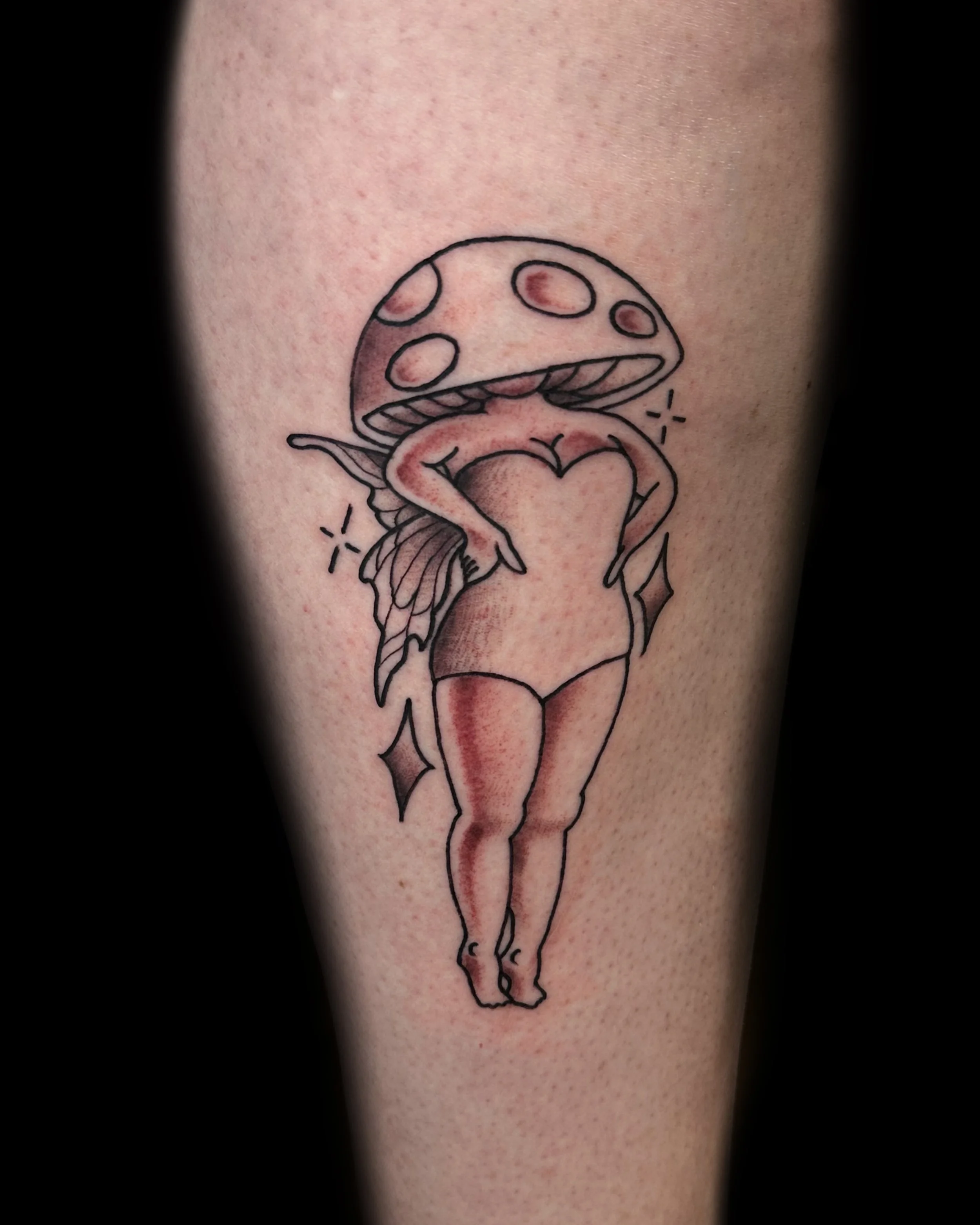 crisp and clean mushroom pinup girl tattoo on arm. black and grey neo -raditional tattoo. Vegan tattooer, climbing tattooer, van-life tattooer. 