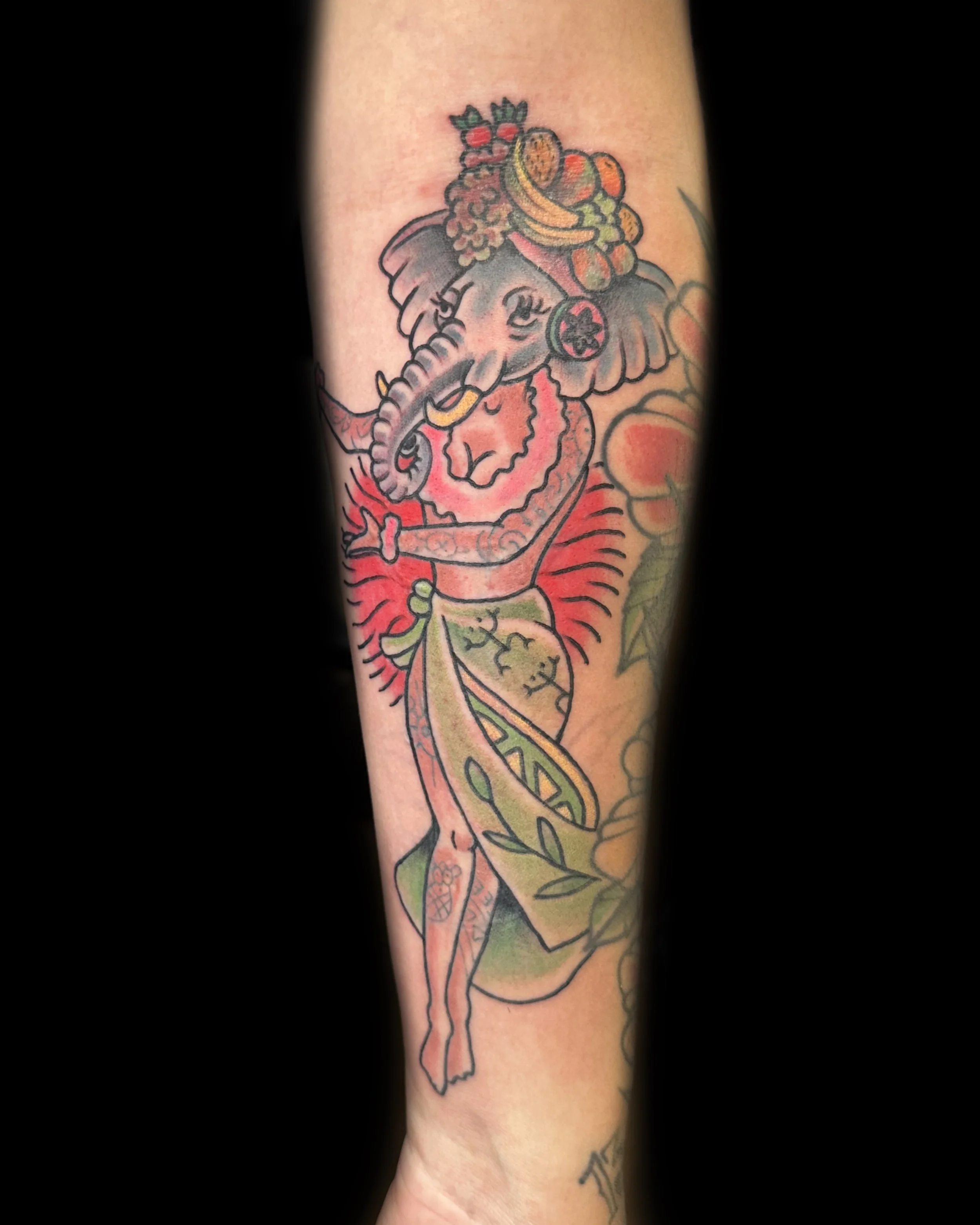 Tattoo of Ganesha, the Hindu elephant deity, with detailed coloring and decorative elements on the arm.