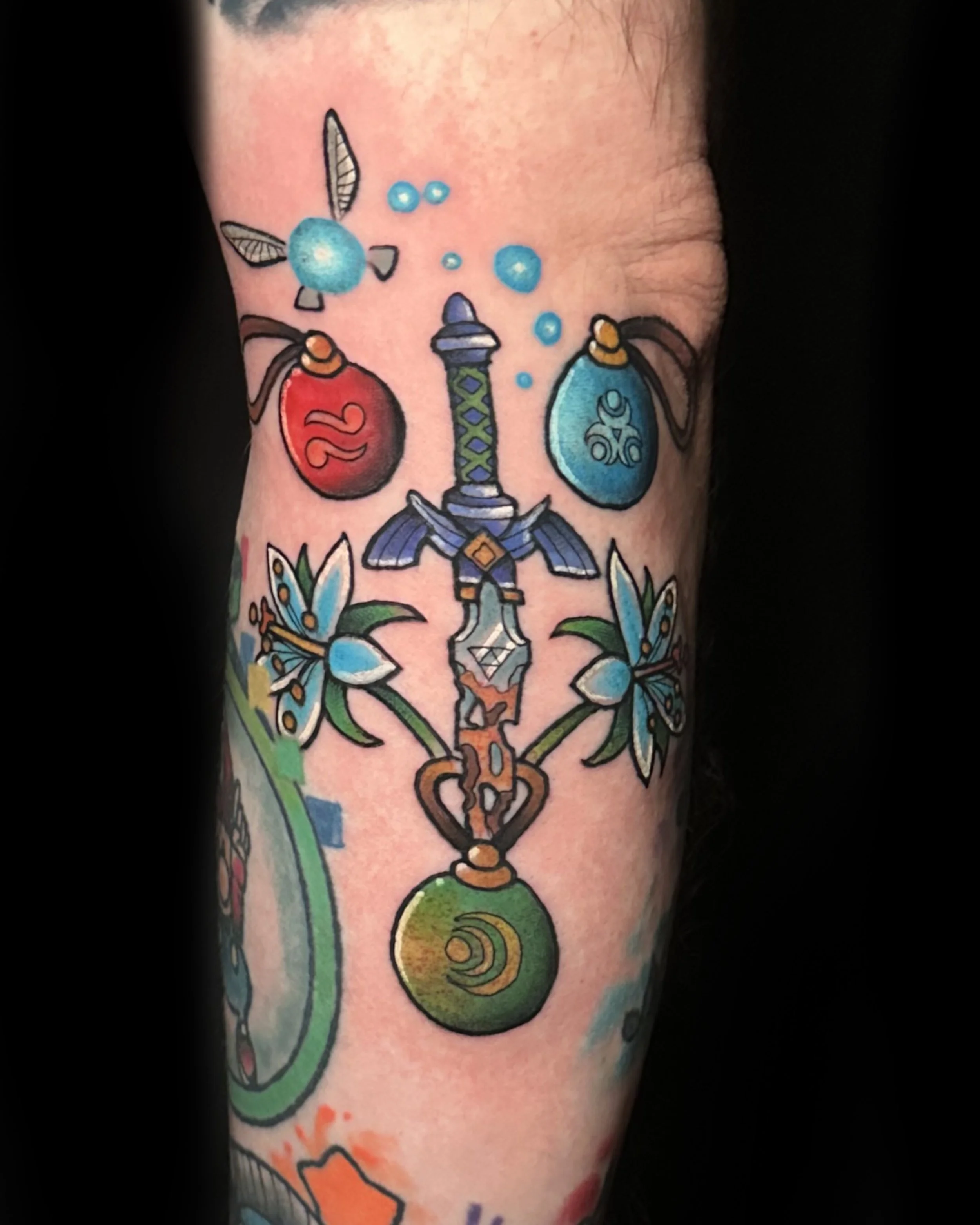 Colorful tattoo of a sword with a green orb at the base, two flowers, and two potion bottles at the top with bubbles.