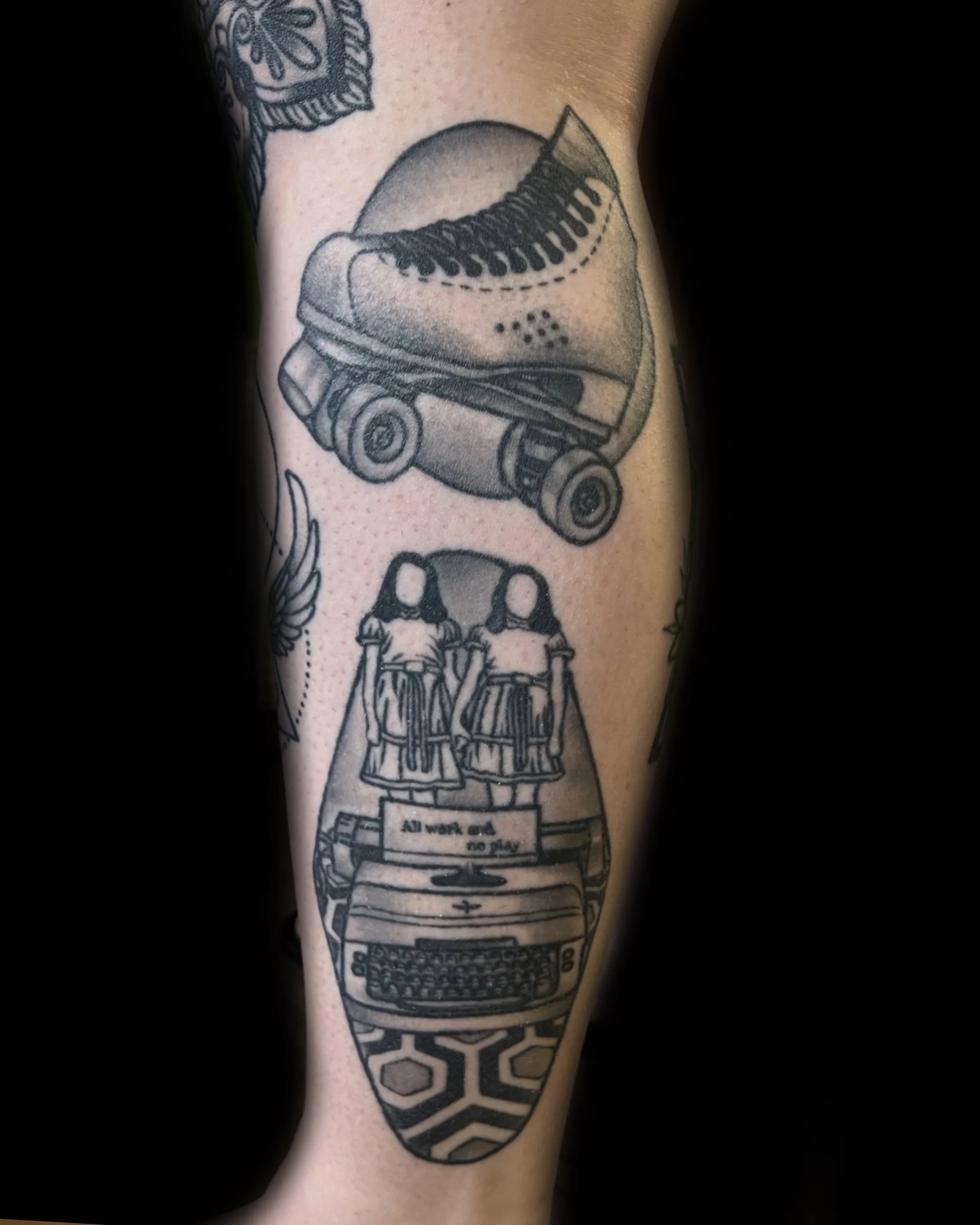 Tattoo of a skate, two girls in dresses, and a typewriter with the words 'All work and no play' on it.