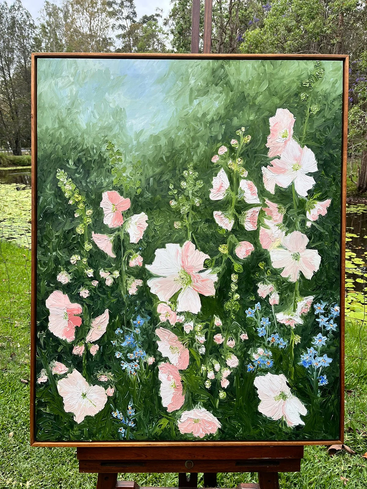 SOLD - 'Spring Carnival', 103cm x 83cm, Oil, Blackwood Frame.
Pink and soft white hollyhocks and blue delphiniums dance up in to a softly muted blue, green sky. Emerald green background. Portrait style oil palette knife painting. 