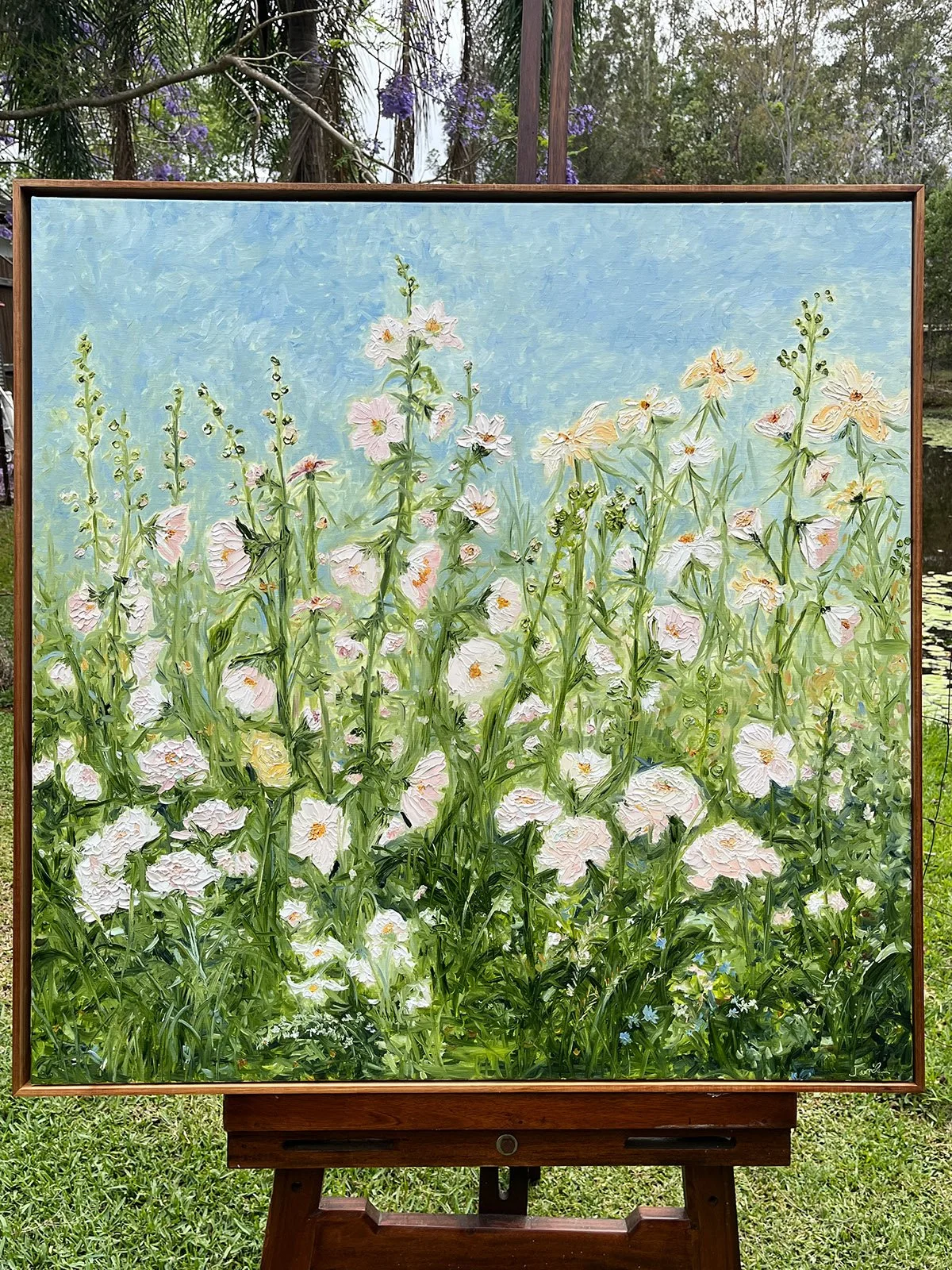 SOLD - 'Old World Delights'. 95cm x95cm, oil, blackwood frame. Hollyhocks are the focal point in this beautiful oil painting. Layers of emerald and lime green set against a soft sage and blue sky.