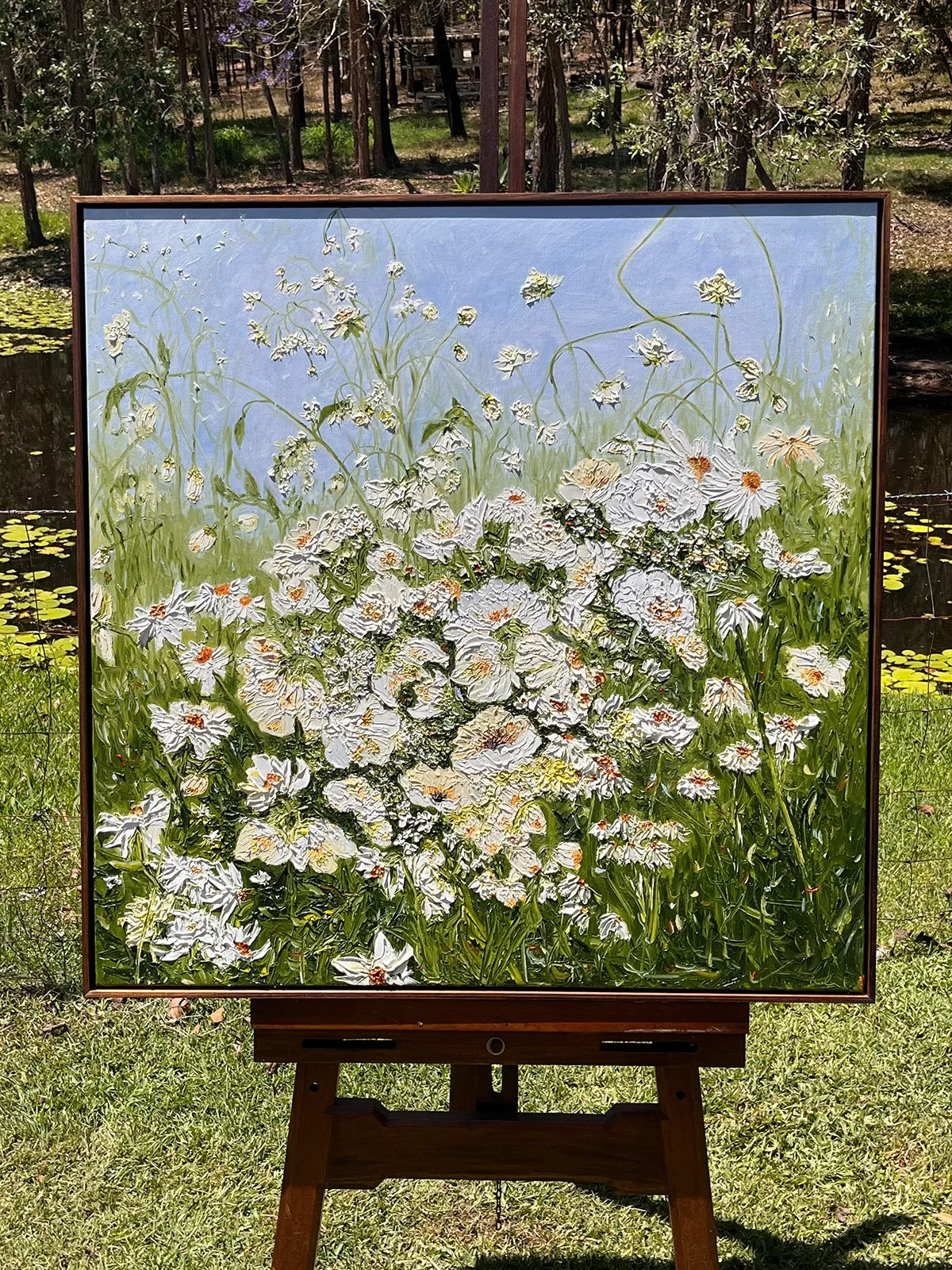 SOLD - 'The Beauty Trap', 95cm x 95cm, oil, framed in blackwood. 
Big blooms cradled in a field of tall grass under a summer sun. A highly textured oil painting achieved with a palette knife.