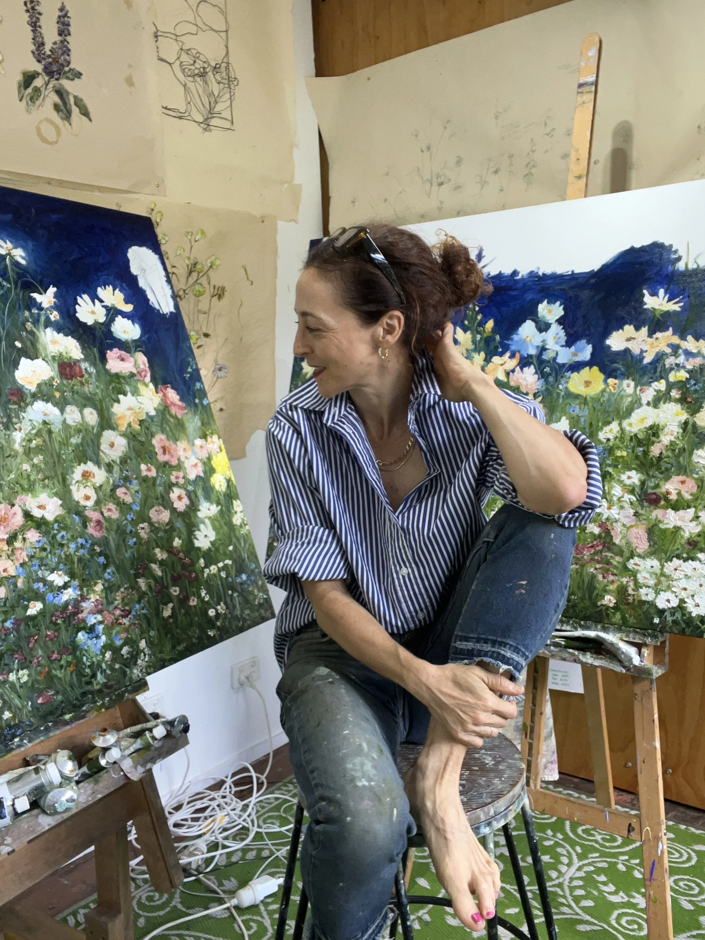artist in her studio stripped dress shirt gold earrings diamonds female oil painter in her studio wildflower meadows deep blue paintings large works expressionism