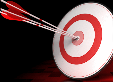 Darts hitting the bullseye on a target board.