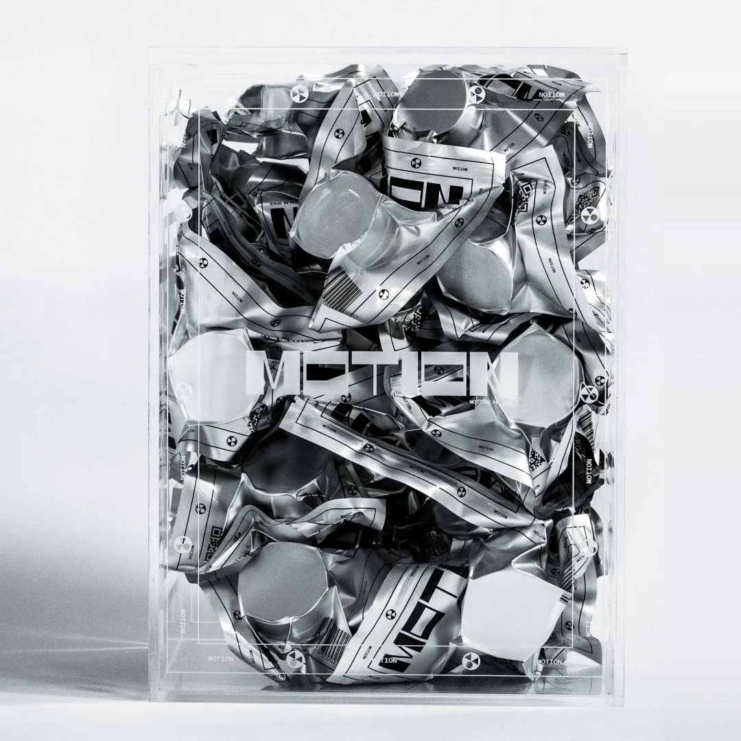 A transparent box filled with crumpled aluminum cans and the word 'METAL' on the front.