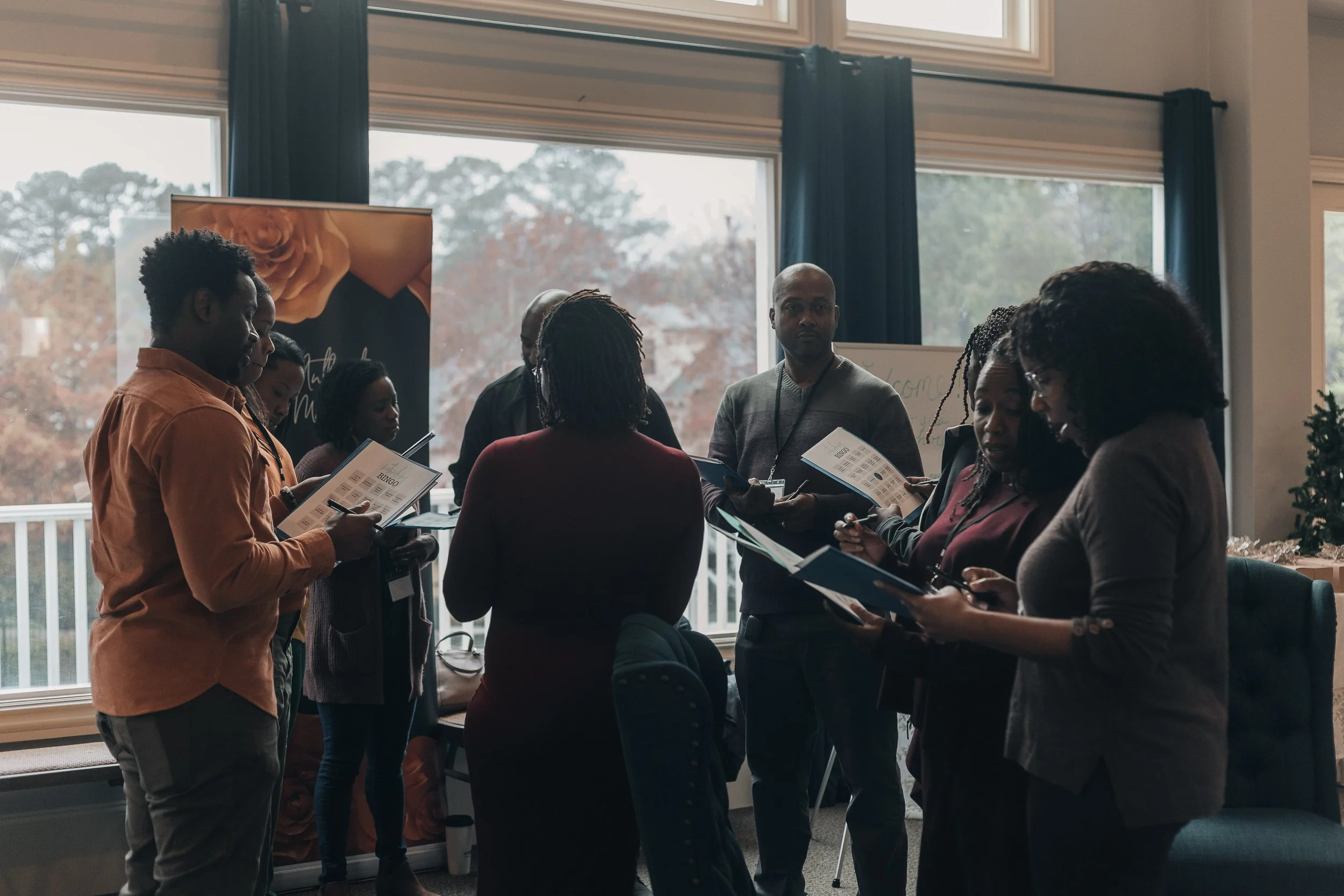 Black couples participating in a relationship workshop, holding materials and engaging in discussion
