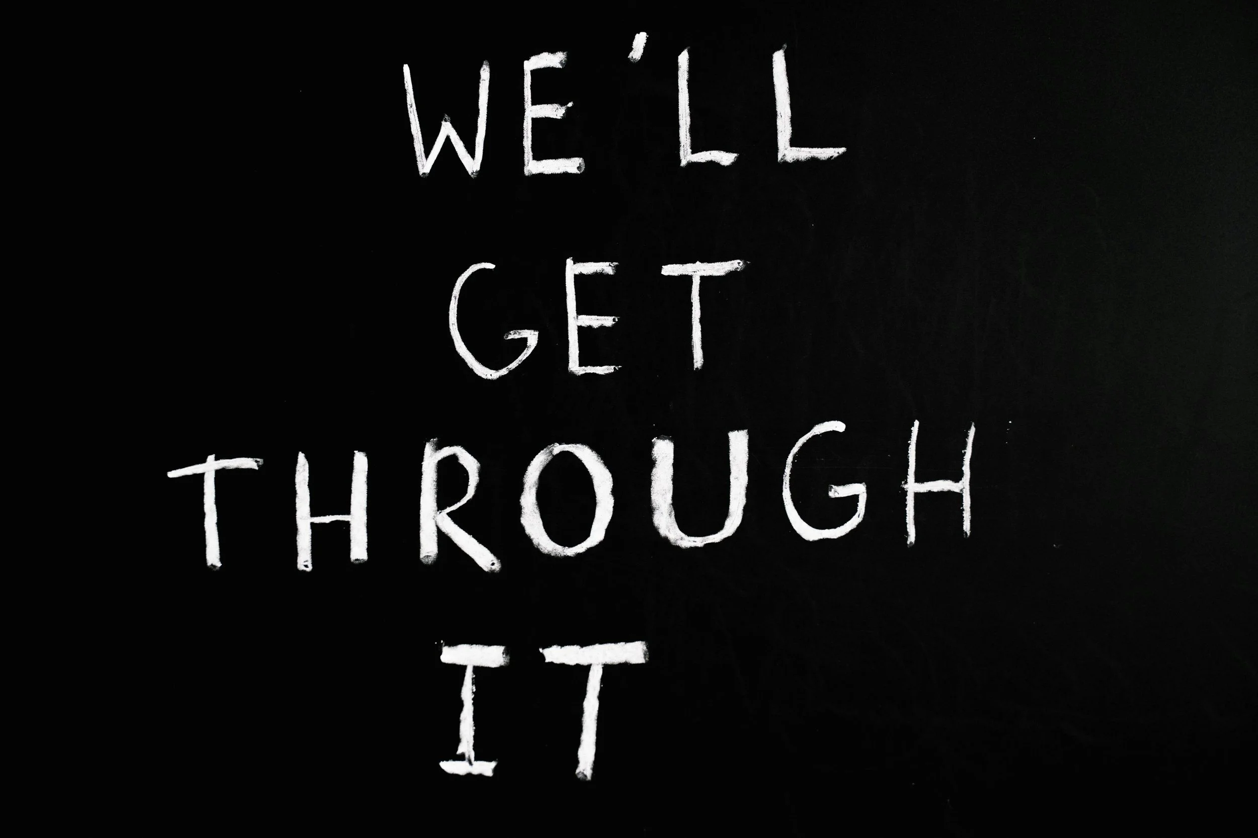 Chalkboard with the message 'Well, I get through' written in white chalk.