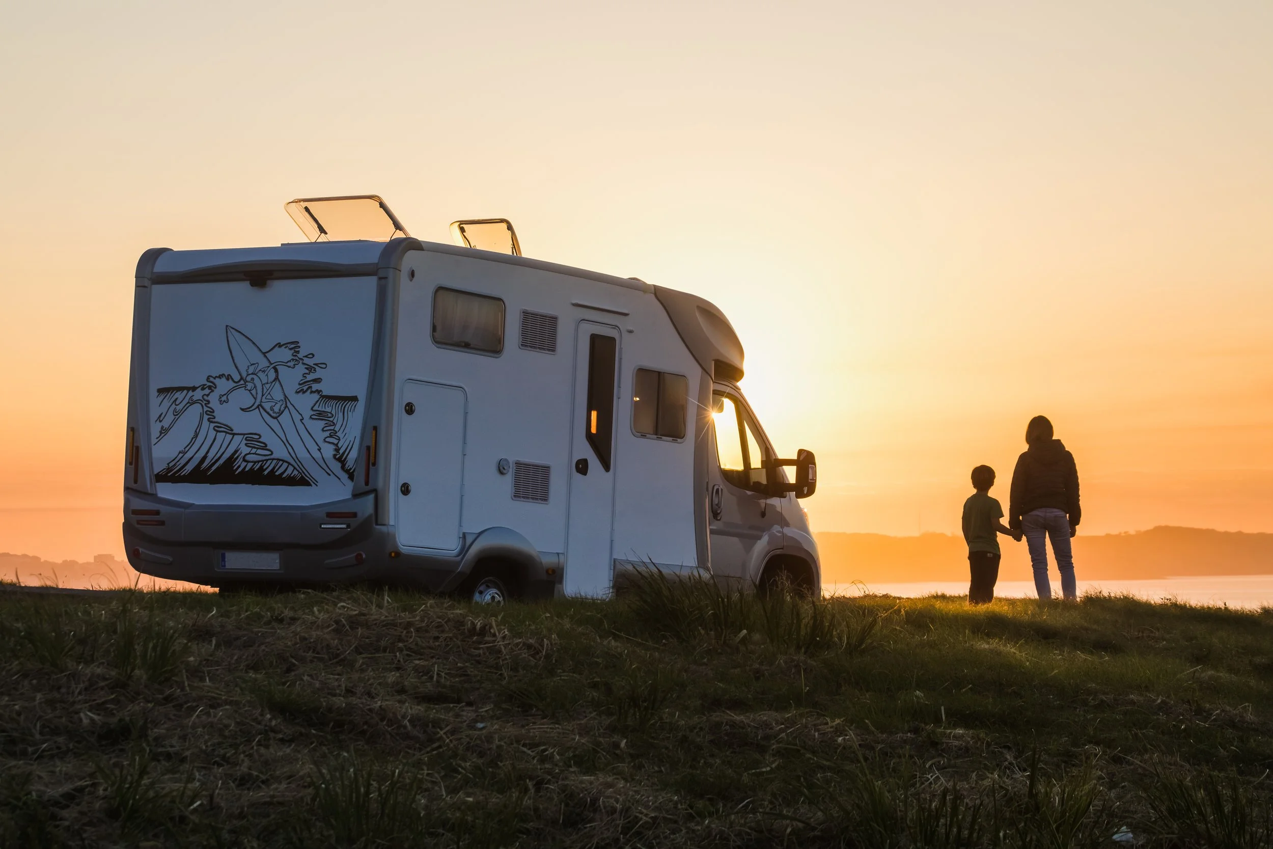 A mother and son stare at the beach outside their RV