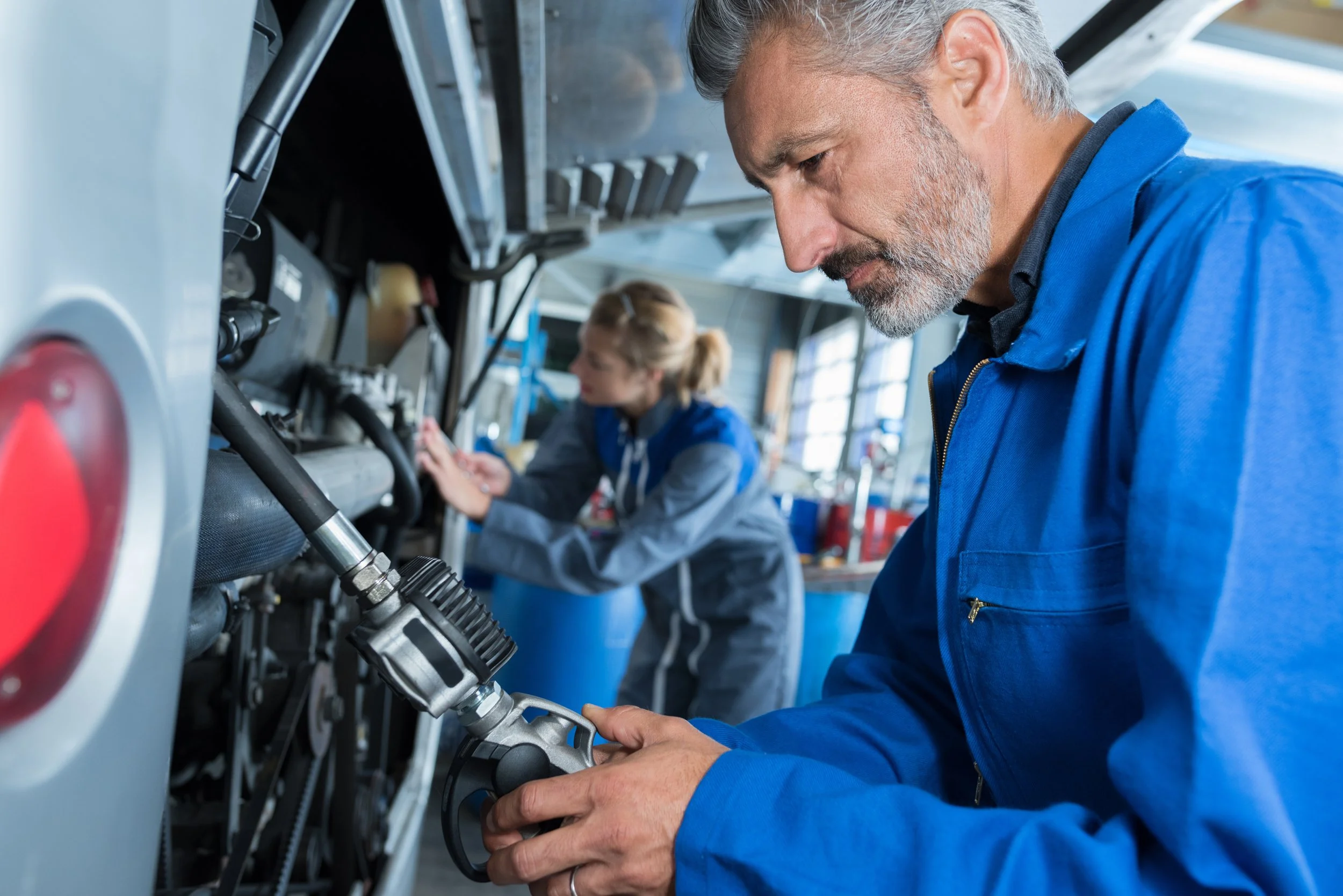 Two mechanics work on an RV in a workshop
