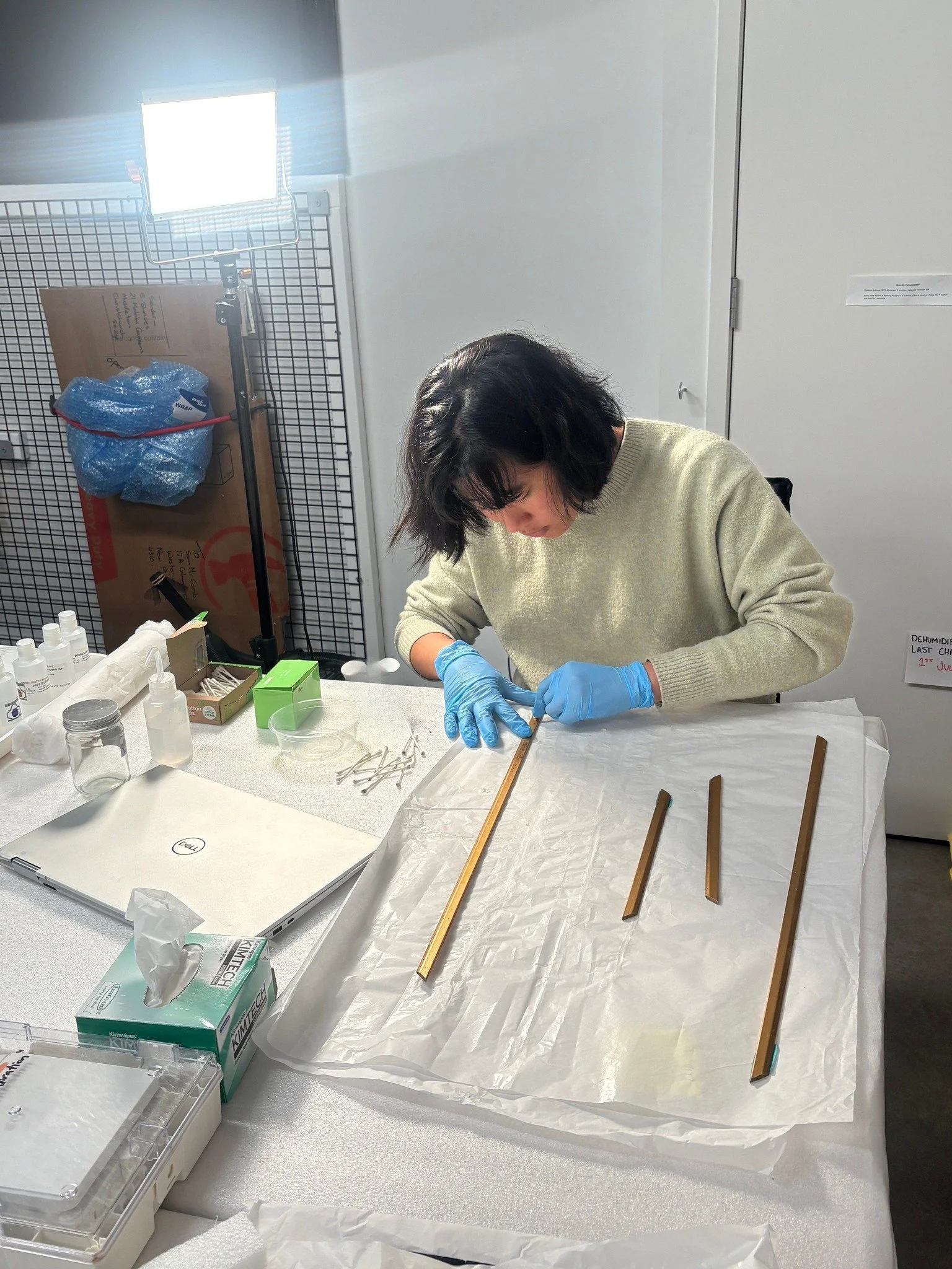 Sometimes the most important part of cleaning is knowing when to stop.

Here, Anne-Marie is carefully cleaning the slip of a framed artwork. Before any treatment begins, small solvent tests help identify what will remove unwanted surface dirt or coat