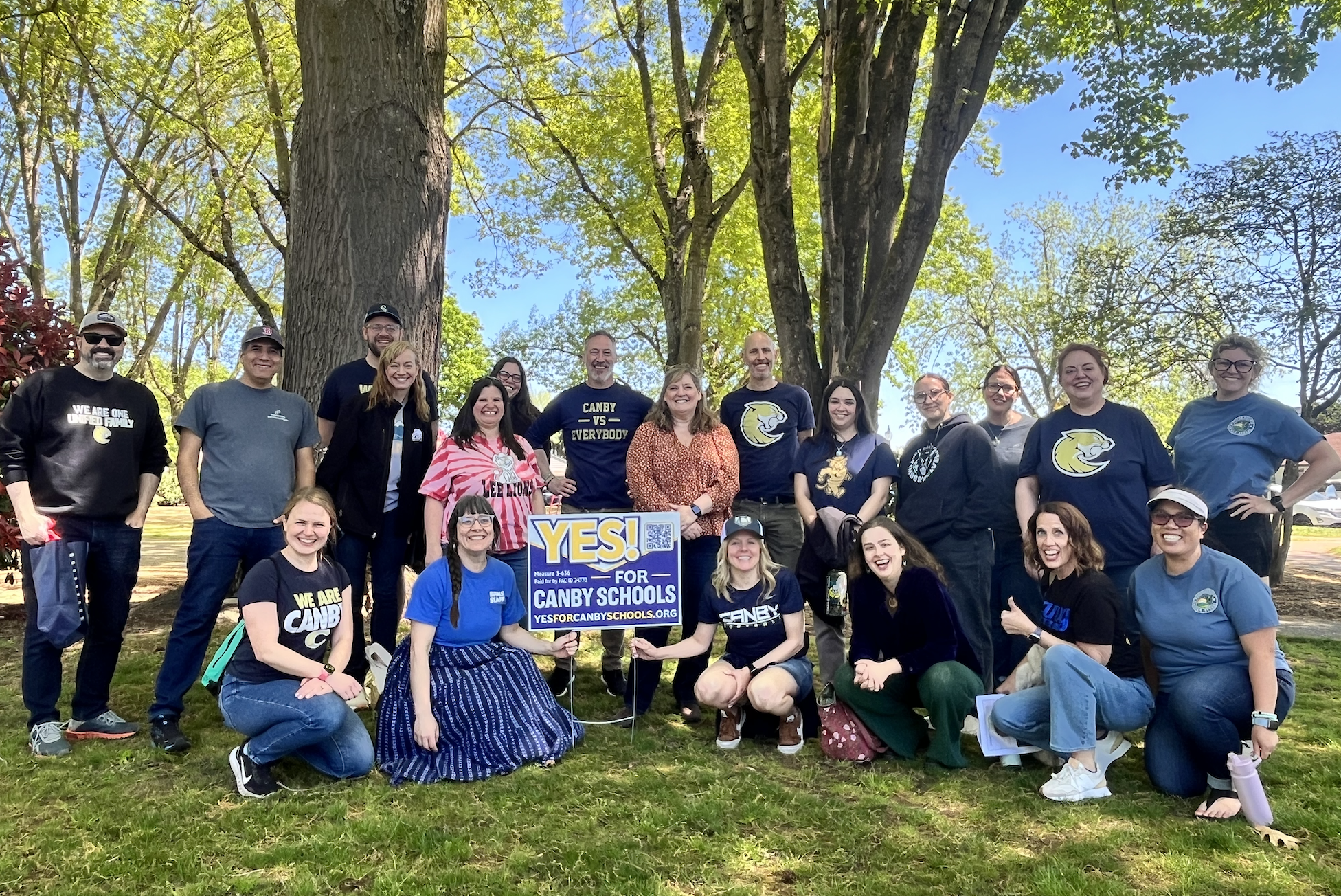 Canby community members in wait park next to a Yes for Canby Schools sign