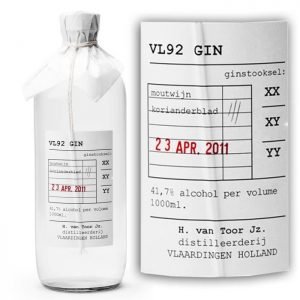 A clear glass bottle with a white label containing information about VL92 GIN, including alcohol content, distiller, and production date of April 23, 2011.