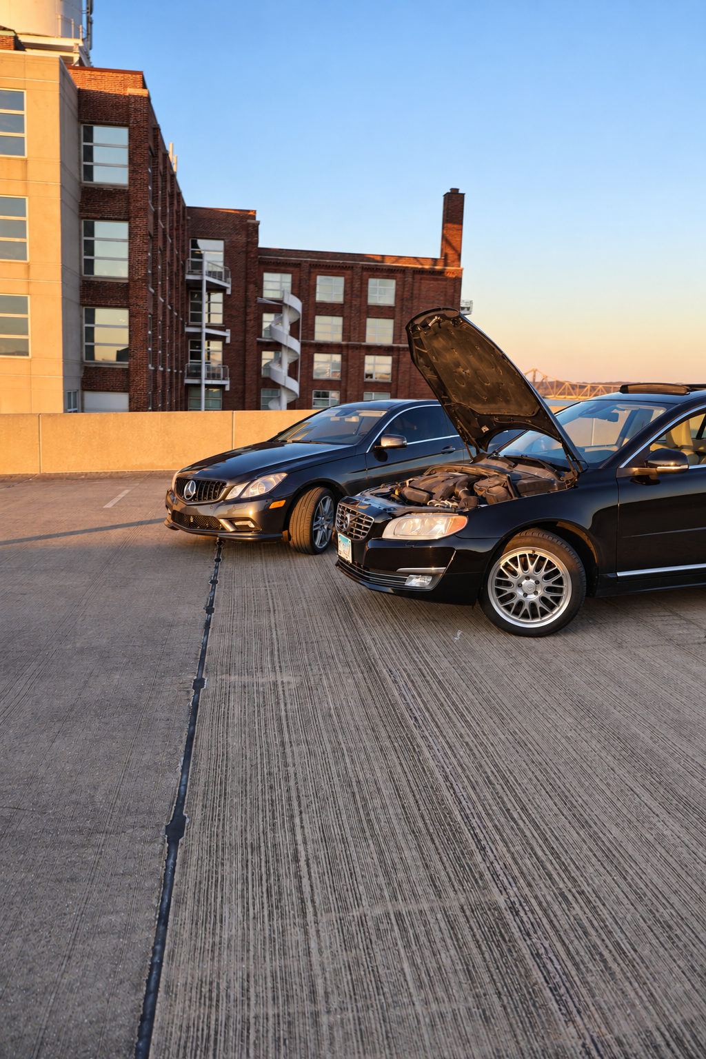 SilvaDes Mercedes E550 coupe with printed intake tubes, parked beside a Volvo S80 T6 on a rooftop at sunset