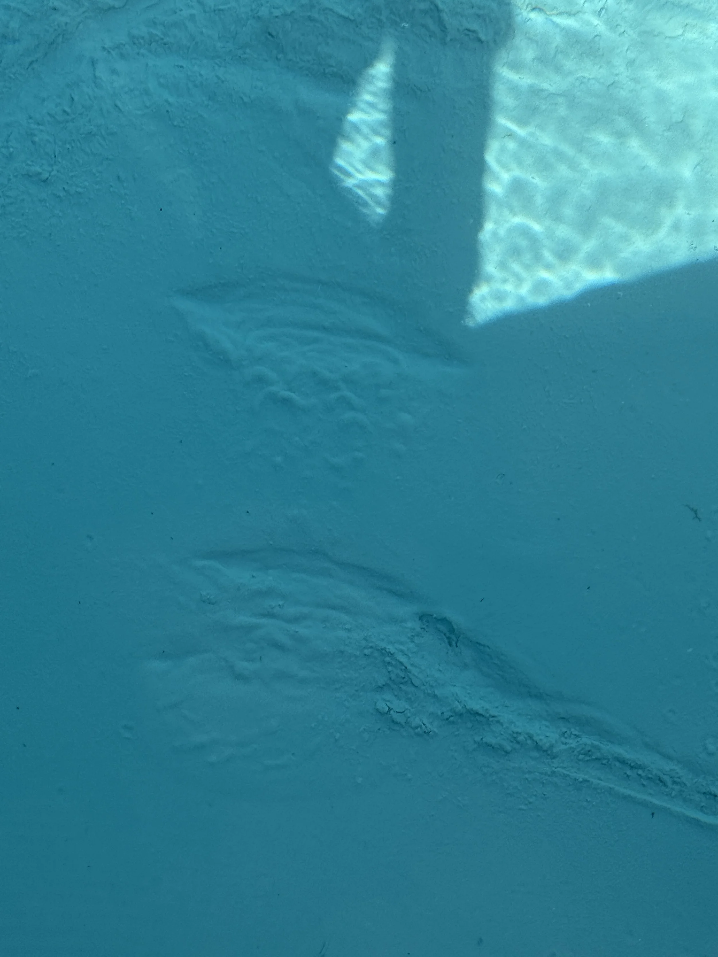 Close-up of a textured surface with a shadow and light reflections.