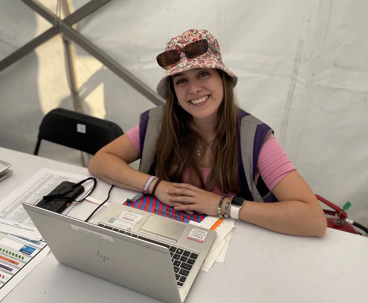 Smiling event professional working at a registration desk, welcoming attendees during a live event.