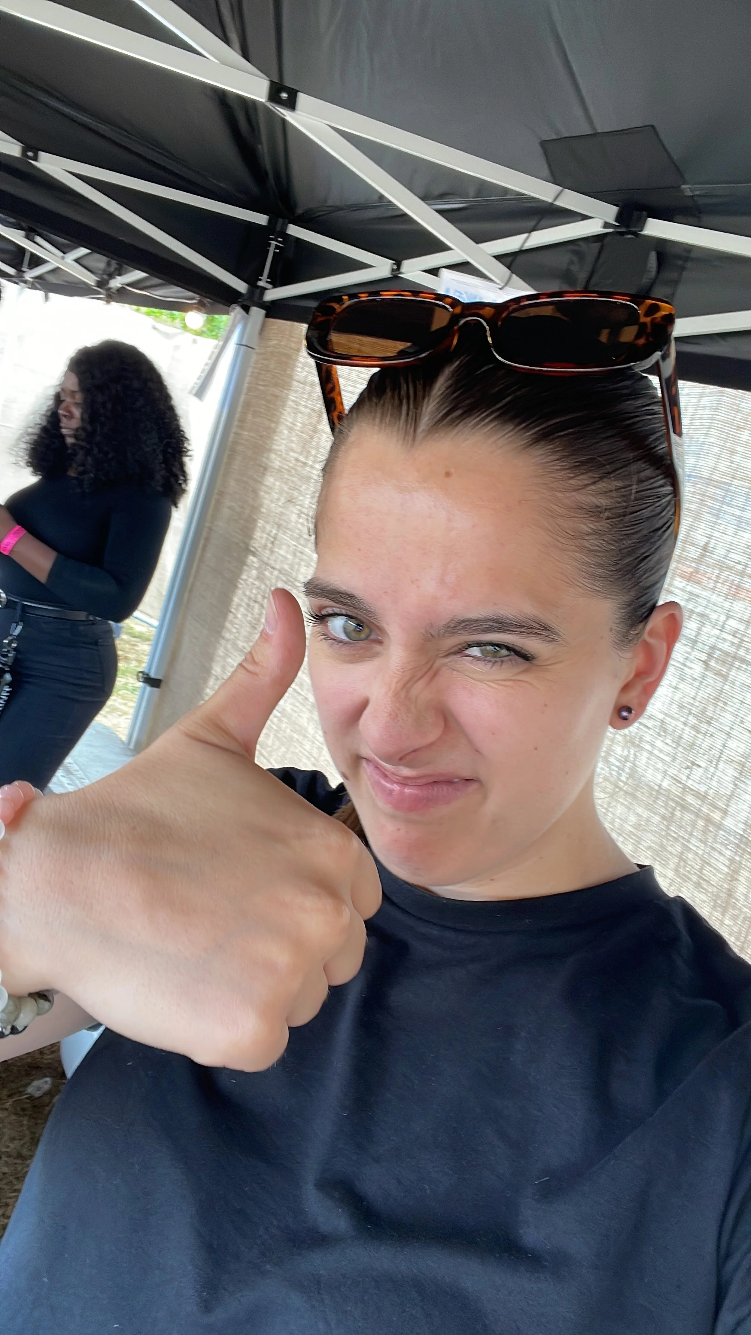 Self-portrait of an event professional giving a thumbs up during a busy event day.