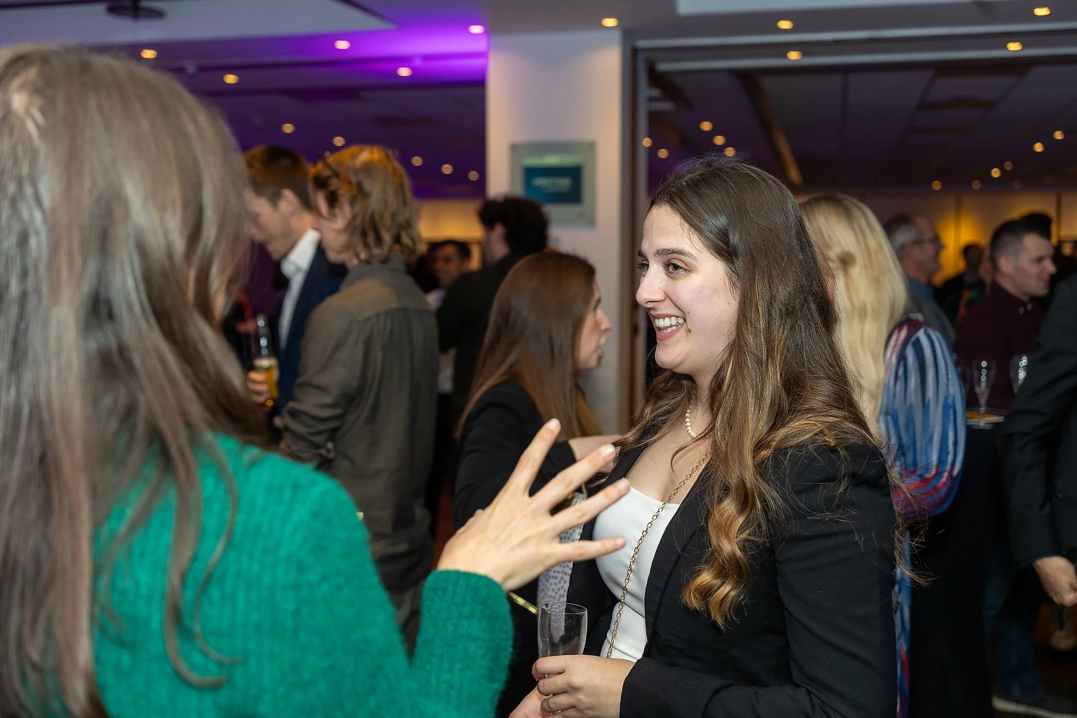 Event professional networking and talking with guests during an evening event.